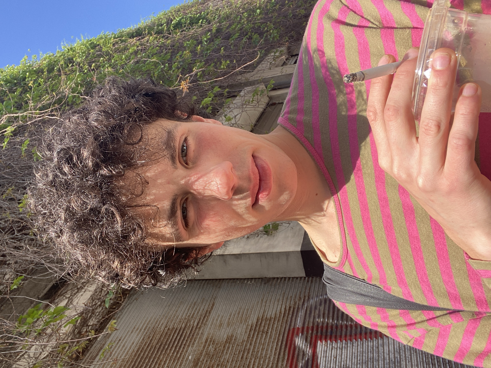 Person smoking cigarette outdoors in Tel Aviv morning