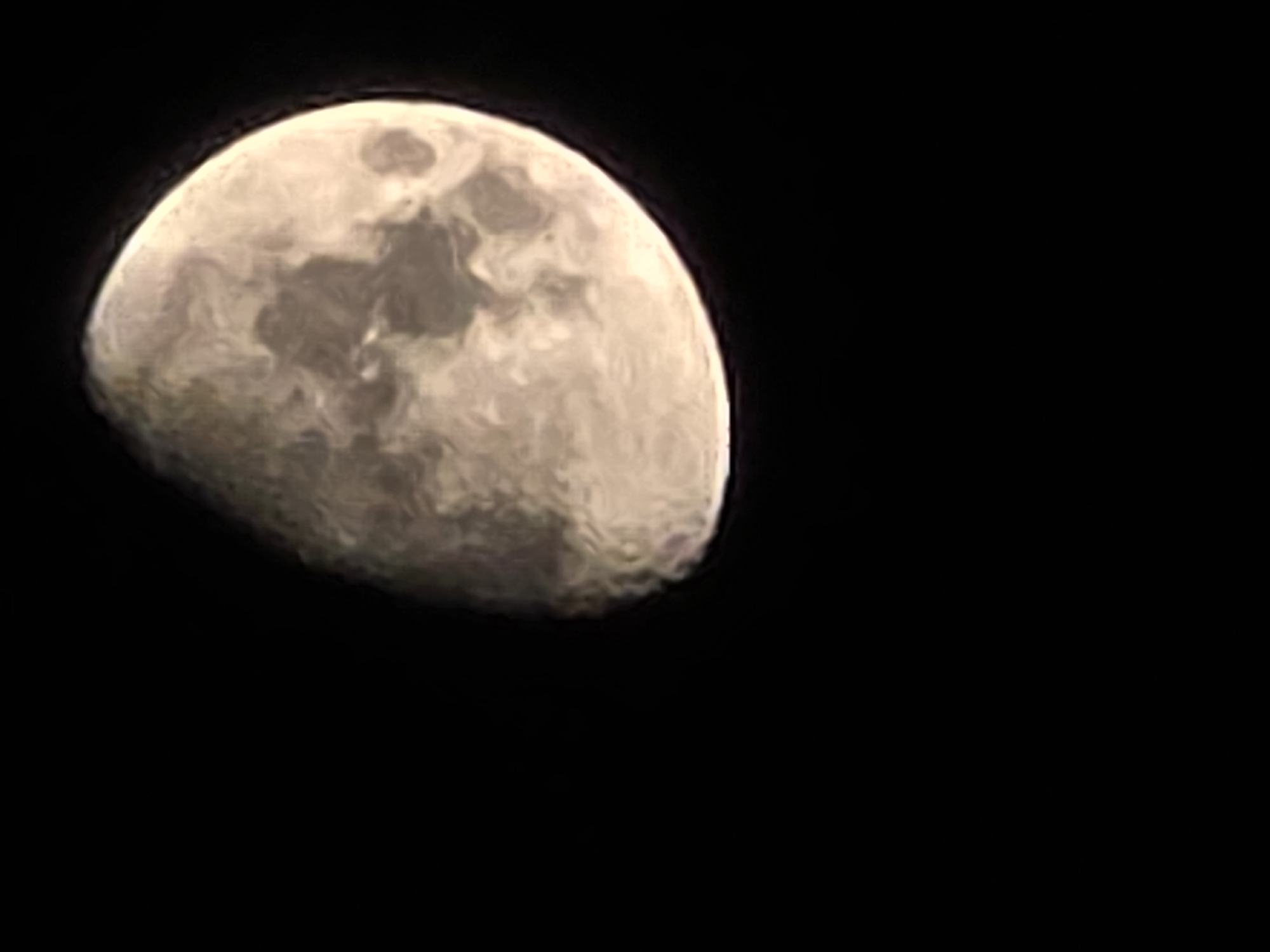 Partially lit moon, close up against a dark sky