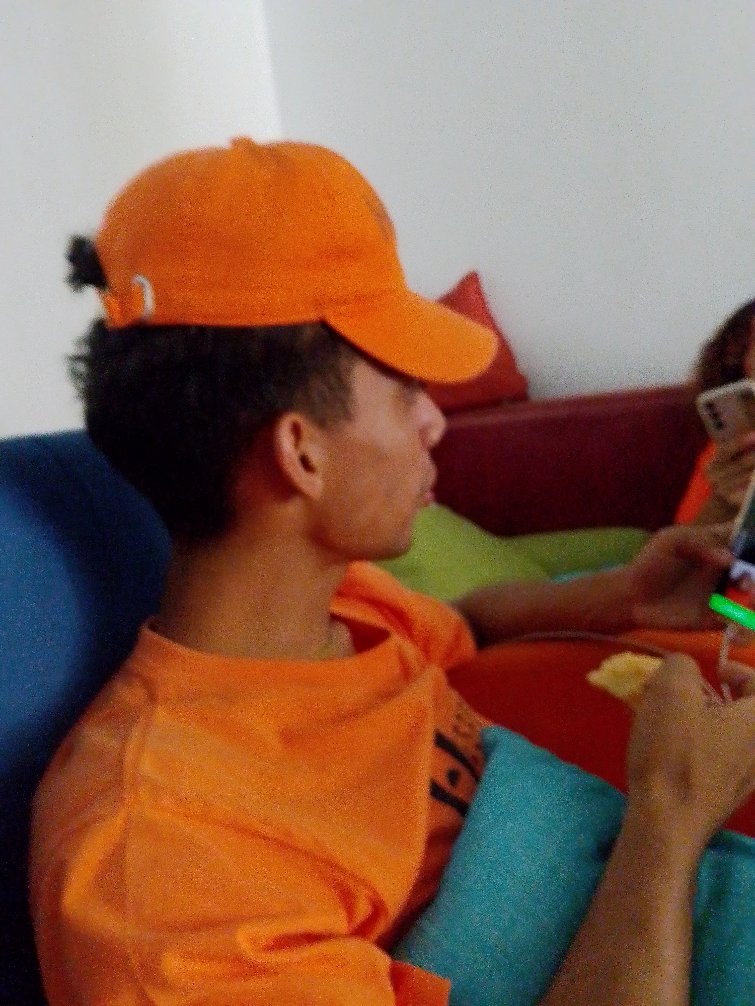 Group in matching orange shirts relax indoors at Venezuelan beach