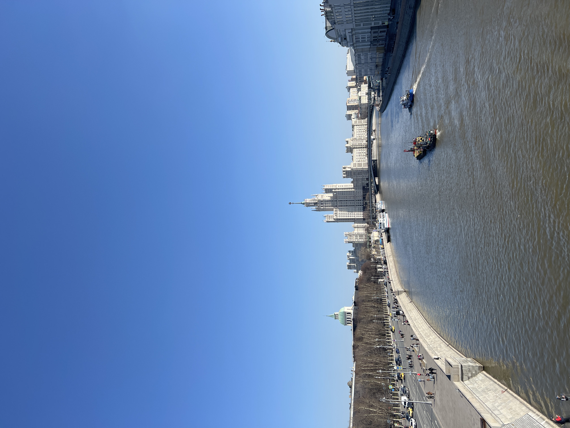 Clear day captures Moscow River scenes with boats, pedestrians