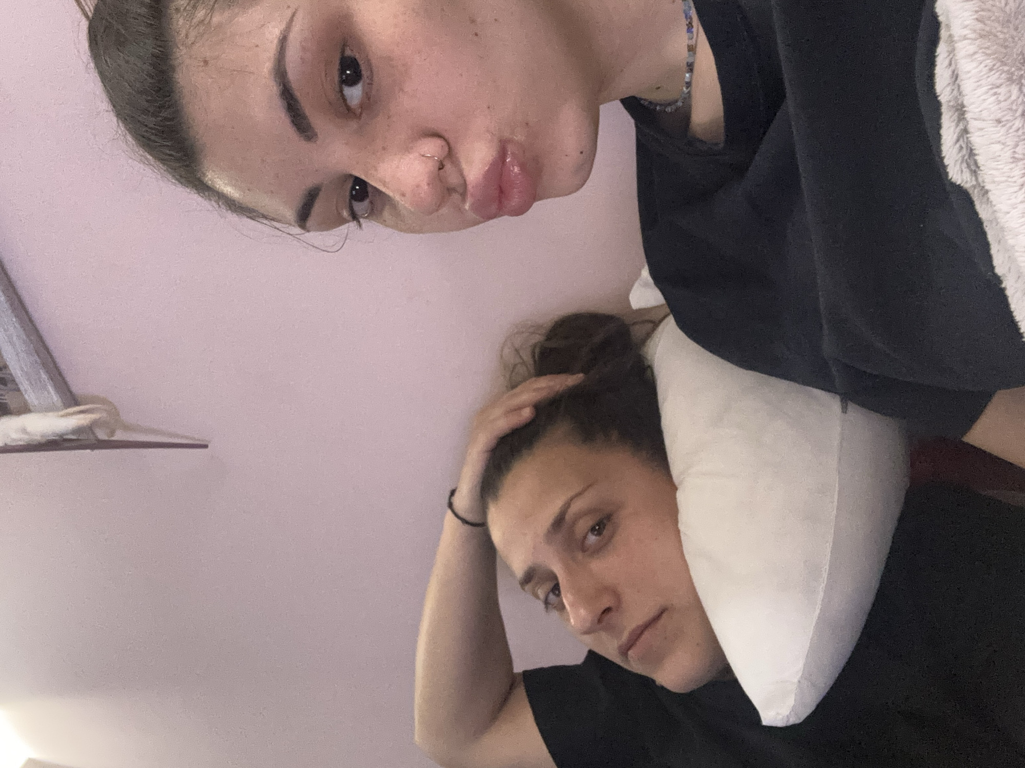 Two women rest indoors in Sofia, one flashing peace sign