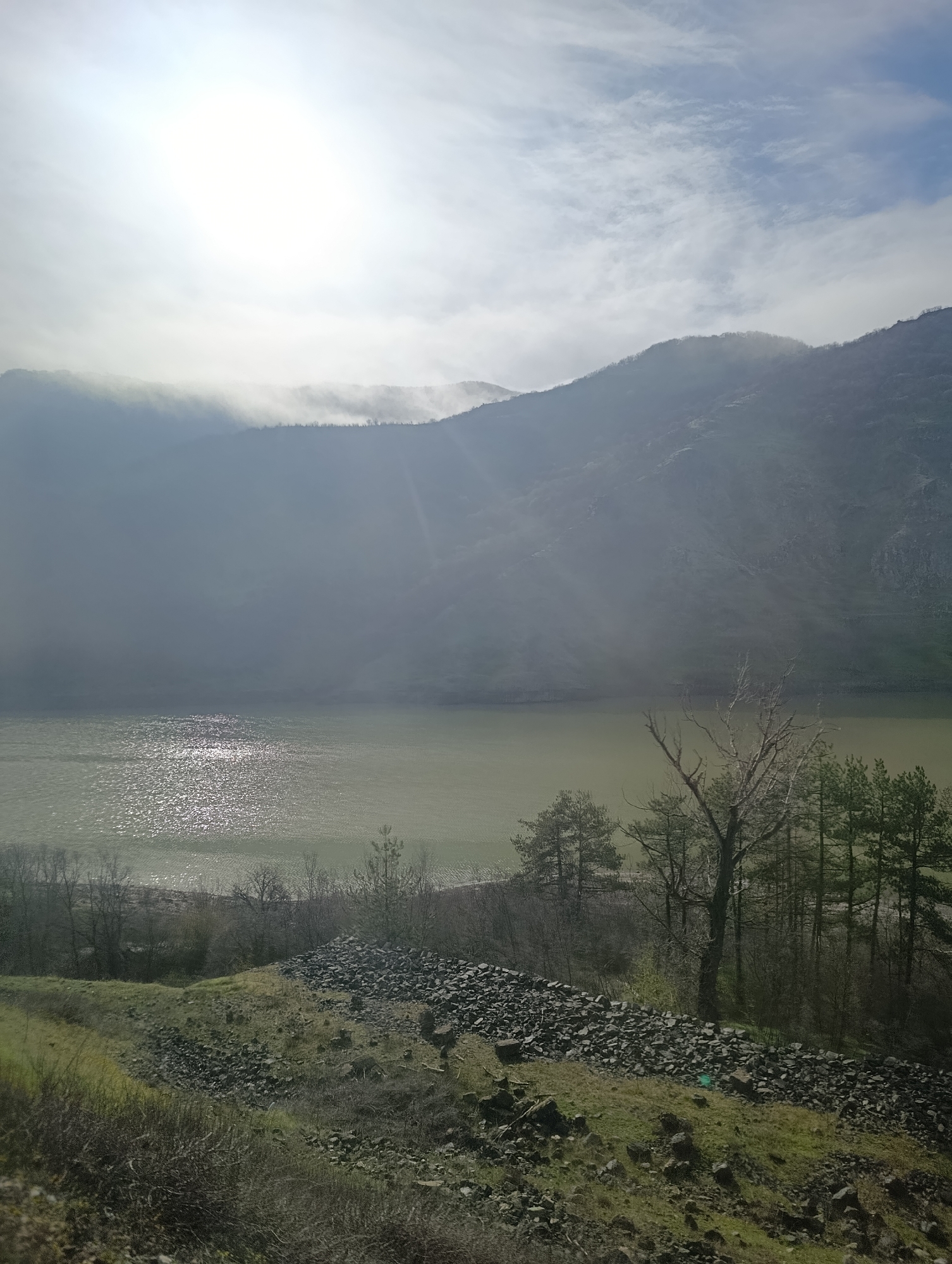 Hazy mountain landscape with water body documented near Lisitsite
