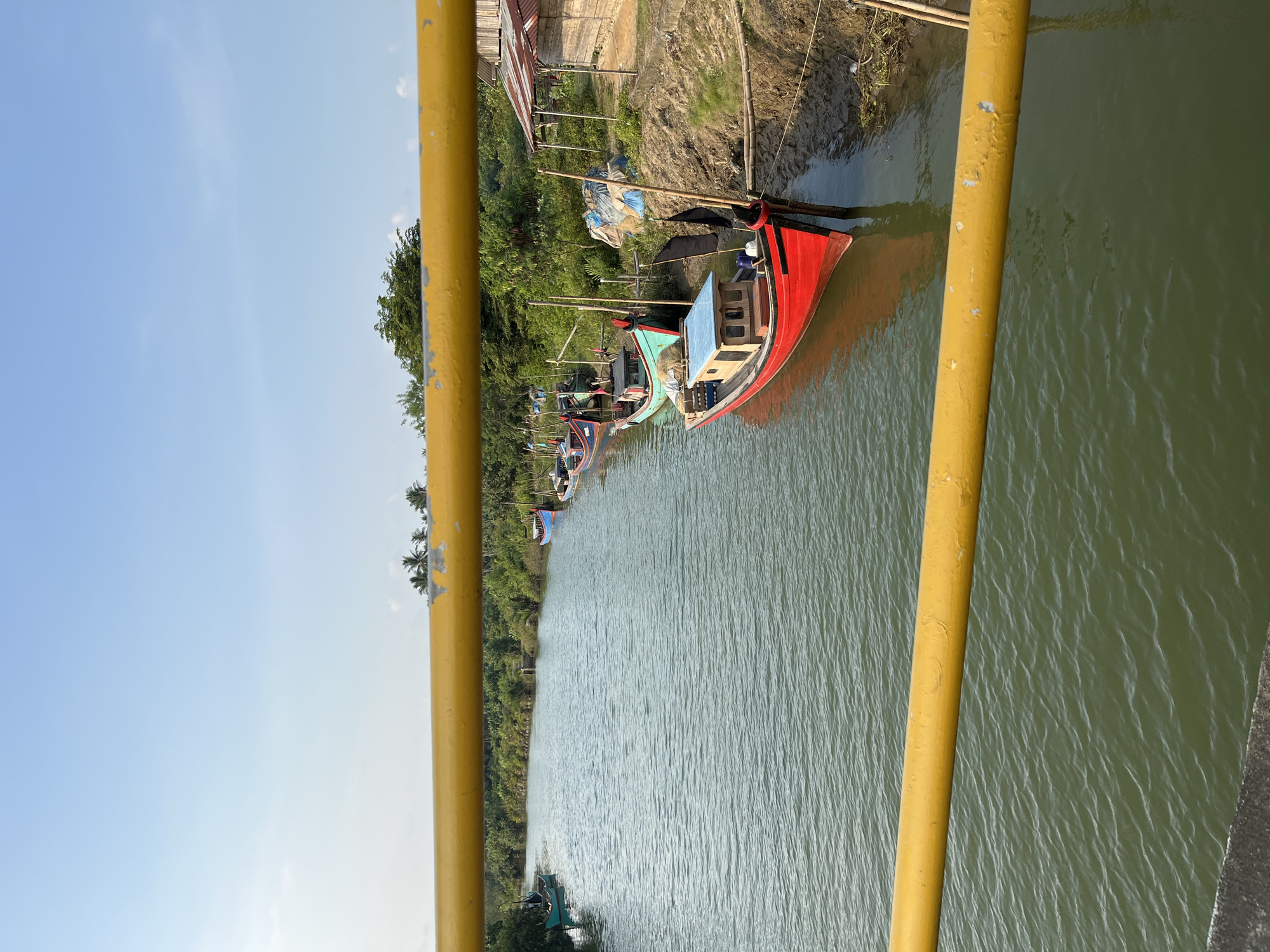 River boats and a truss bridge along the Acehnese coast