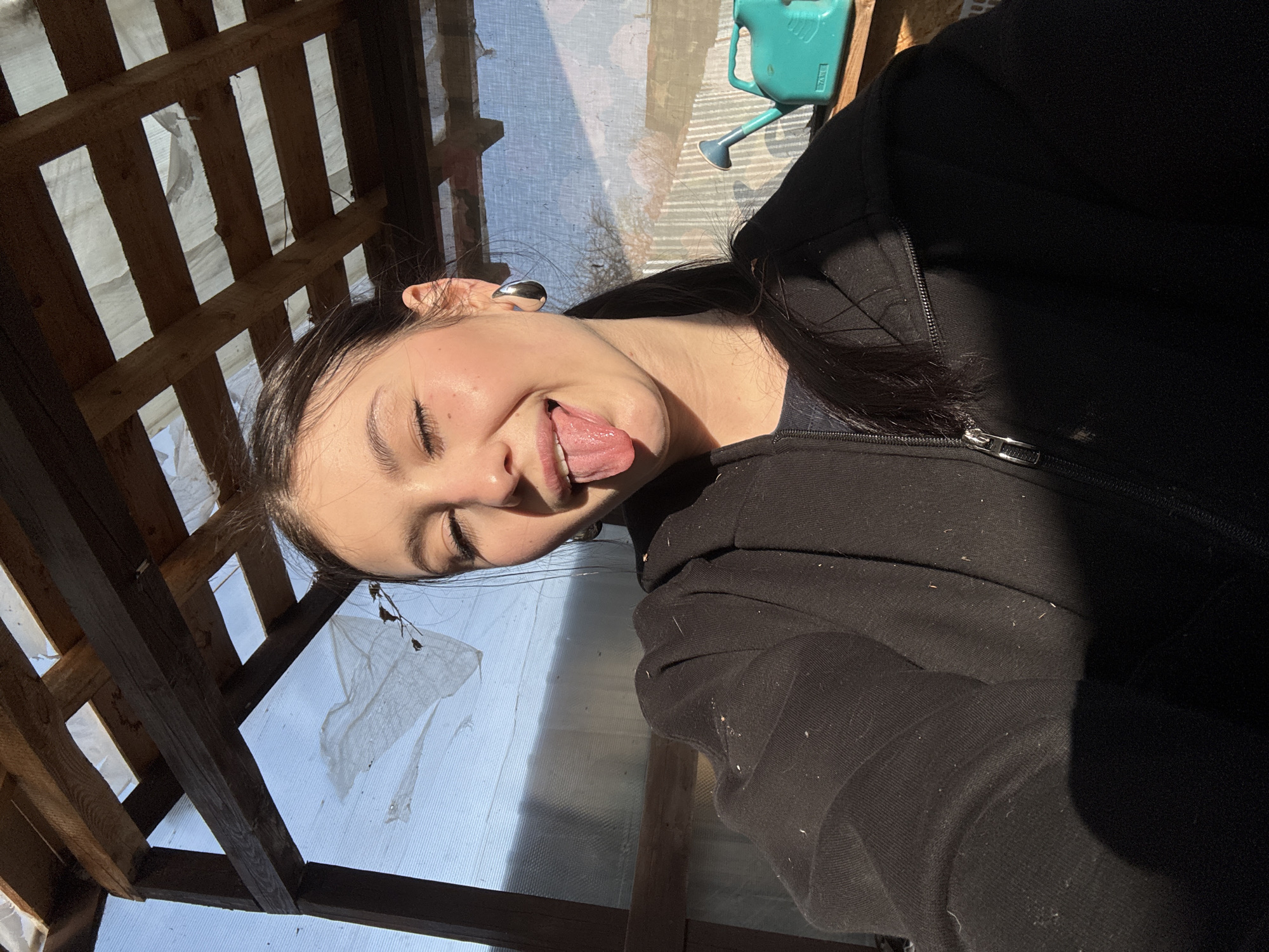 Woman makes playful face in makeshift structure near Фоки
