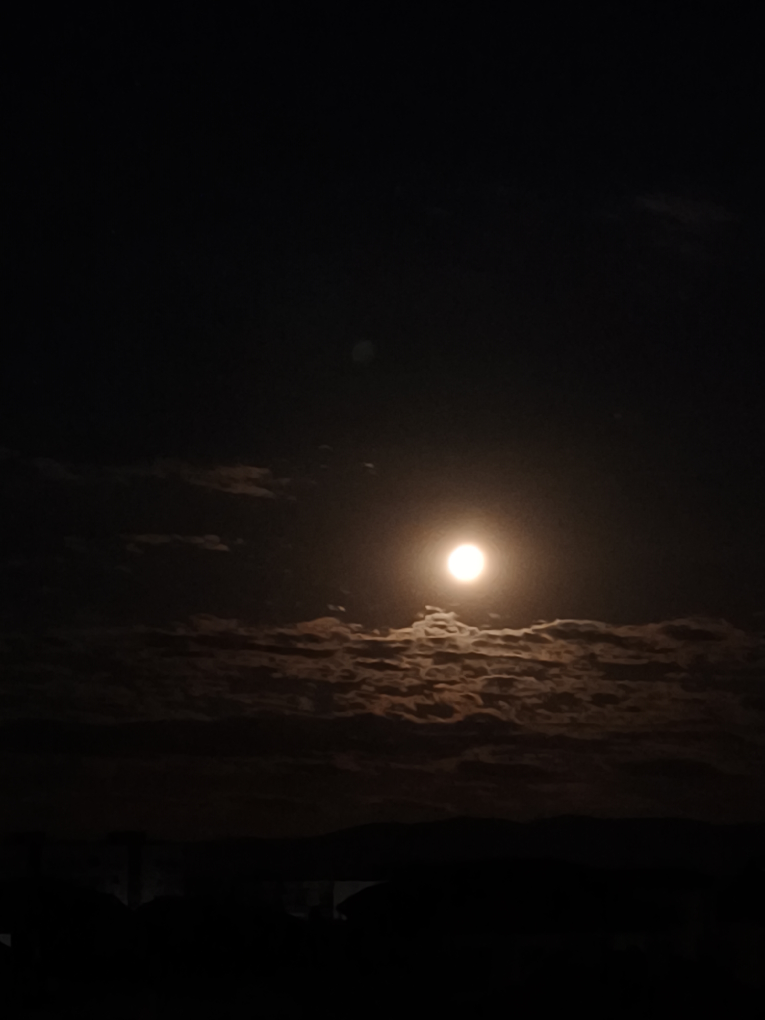 Full moon illuminates cloudy night sky over Svilengrad, Bulgaria