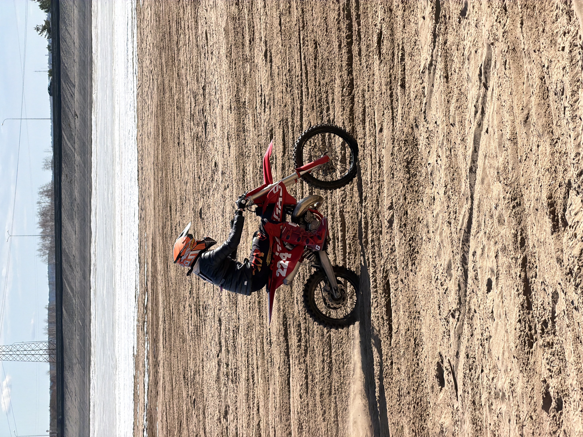 Motocross riders perform stunts near frozen river in Chaikovsky