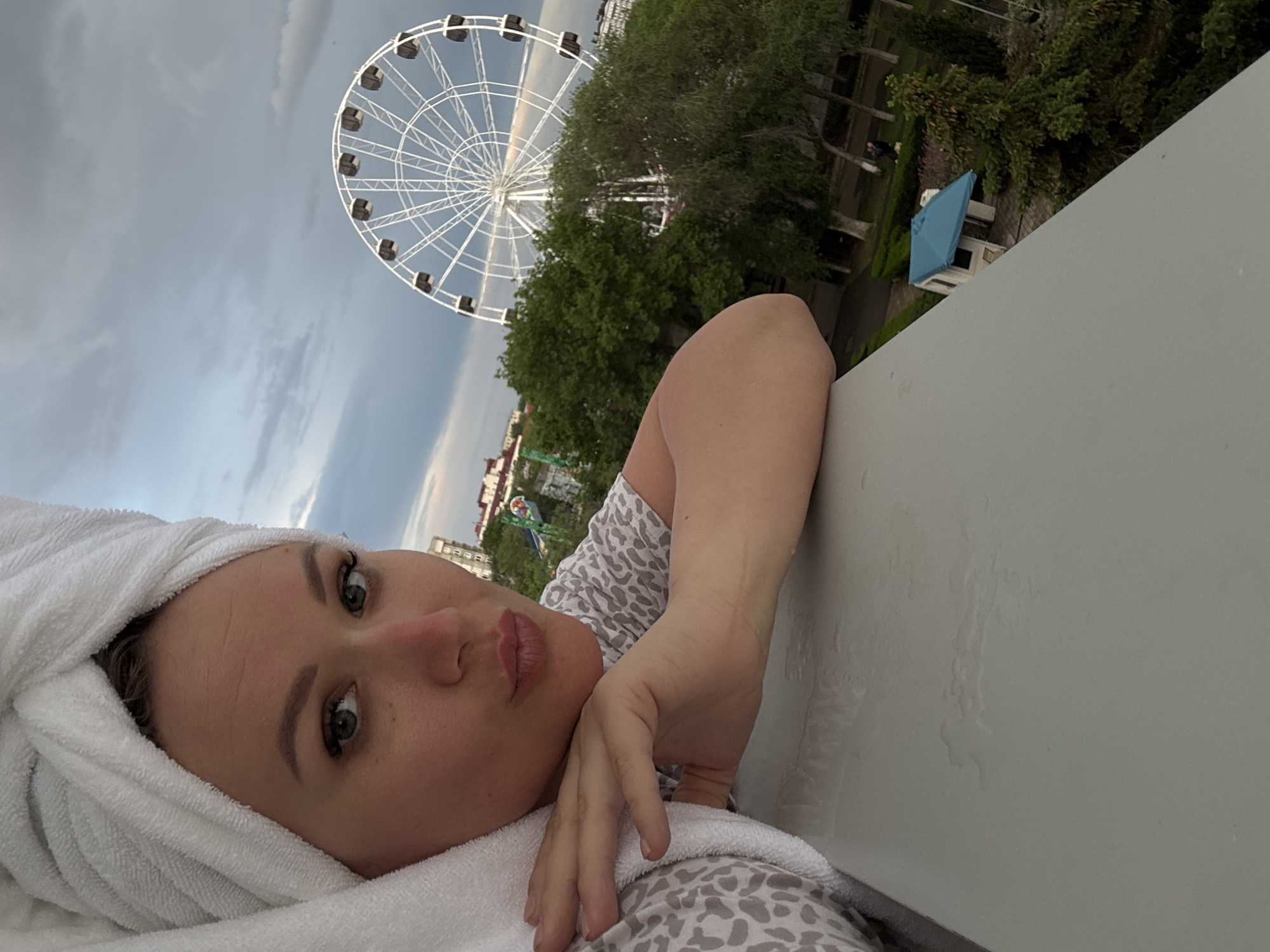 Woman photographed with towel near Ferris wheel in Yevpatoriya