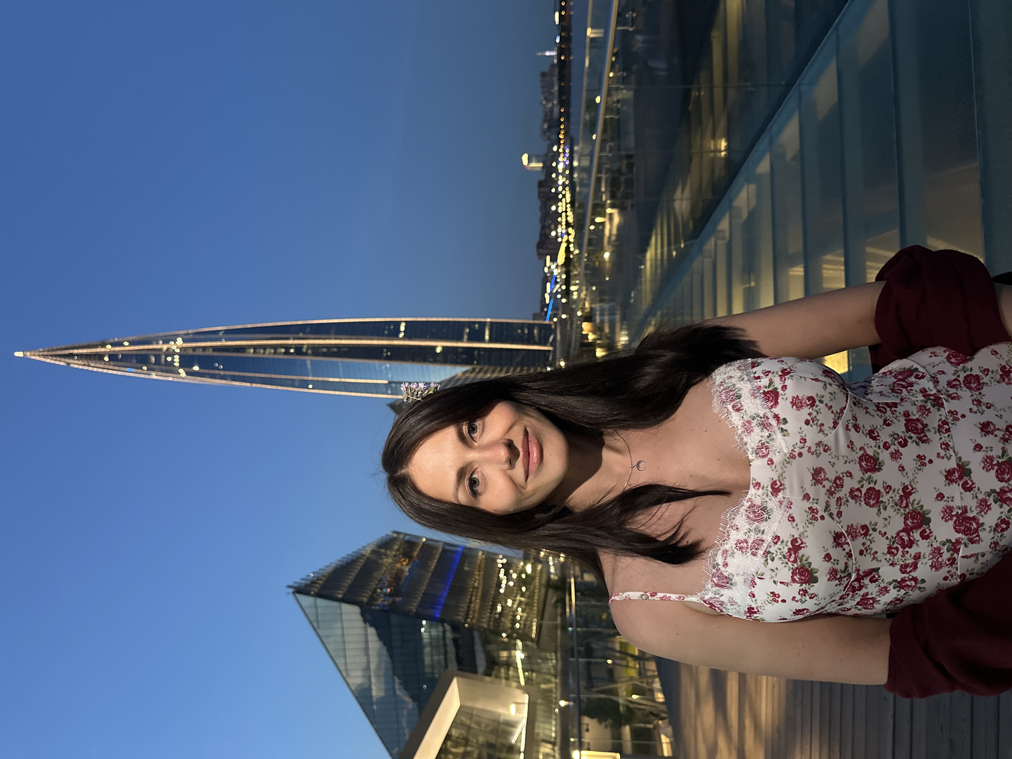 Woman poses for extended photo session near Lakhta Center at dusk