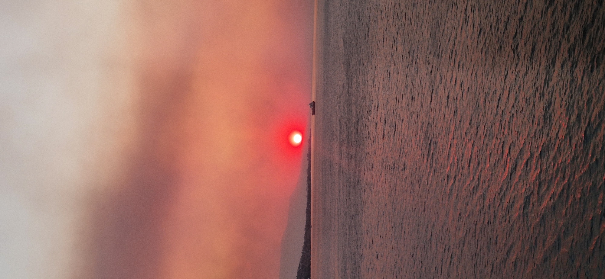 Cargo ship crosses a fiery sunset off the Greek coast