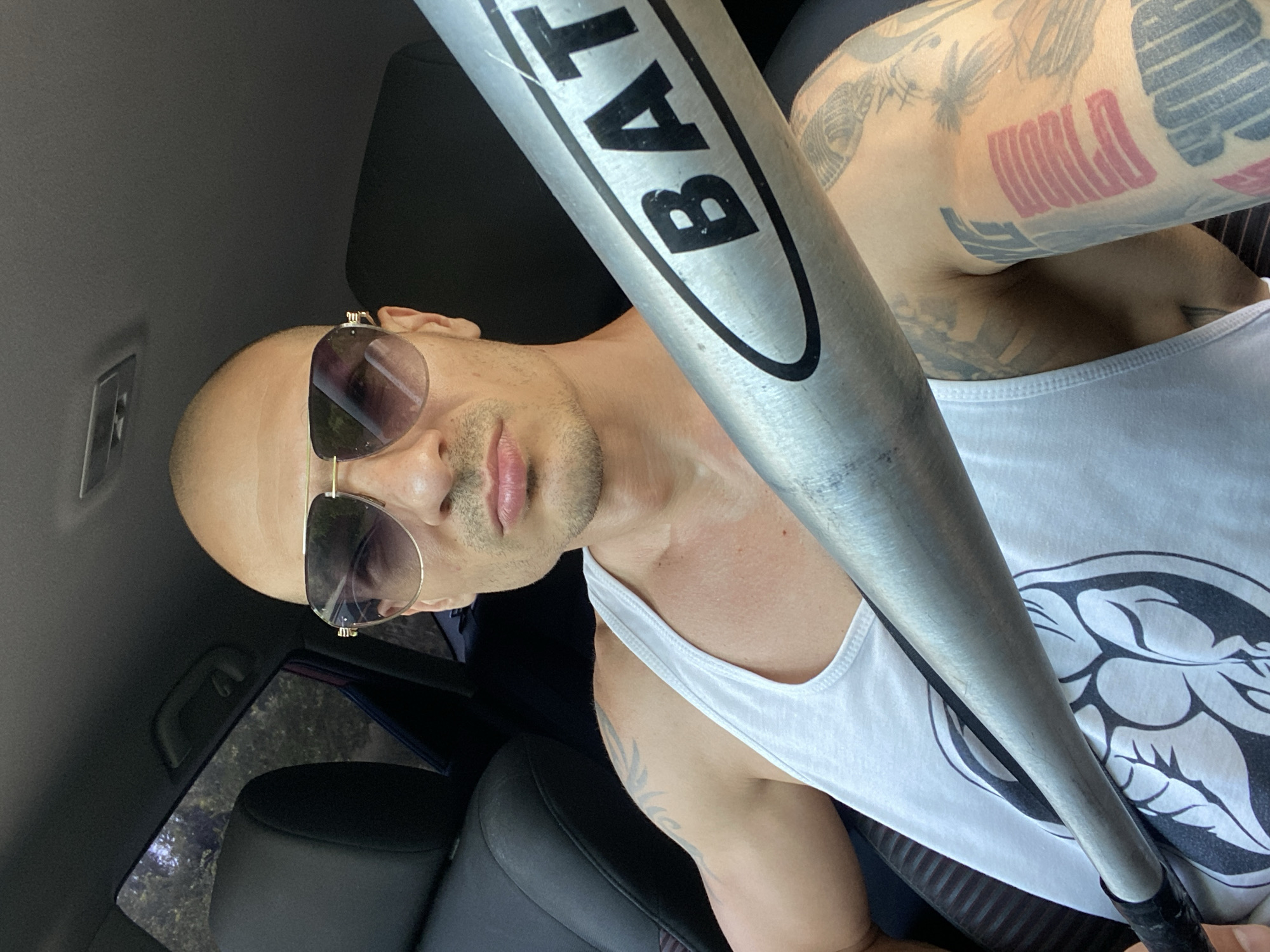 Tattooed person with baseball bat photographed in car, Pleven