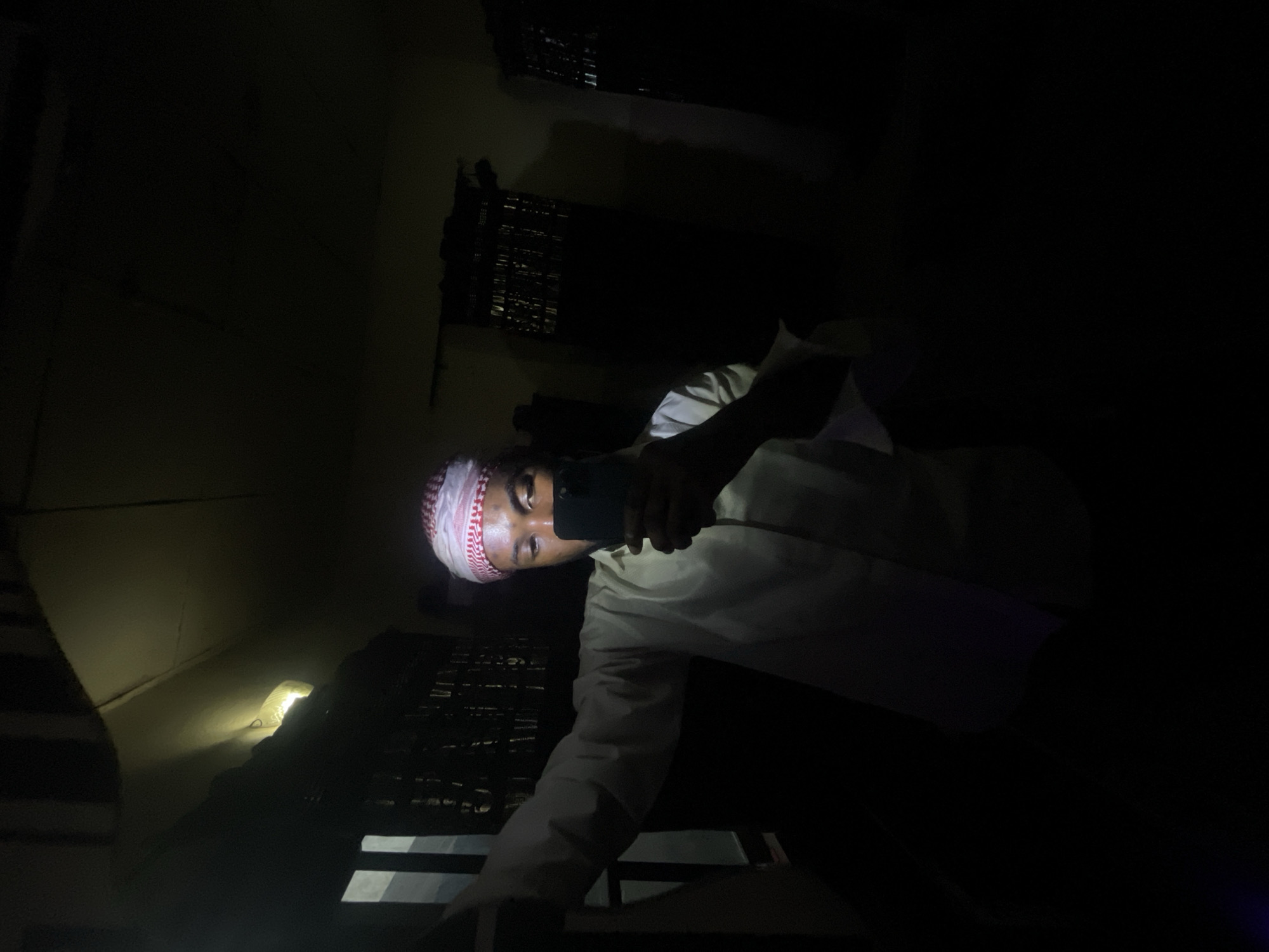 Man takes selfies in dimly lit room