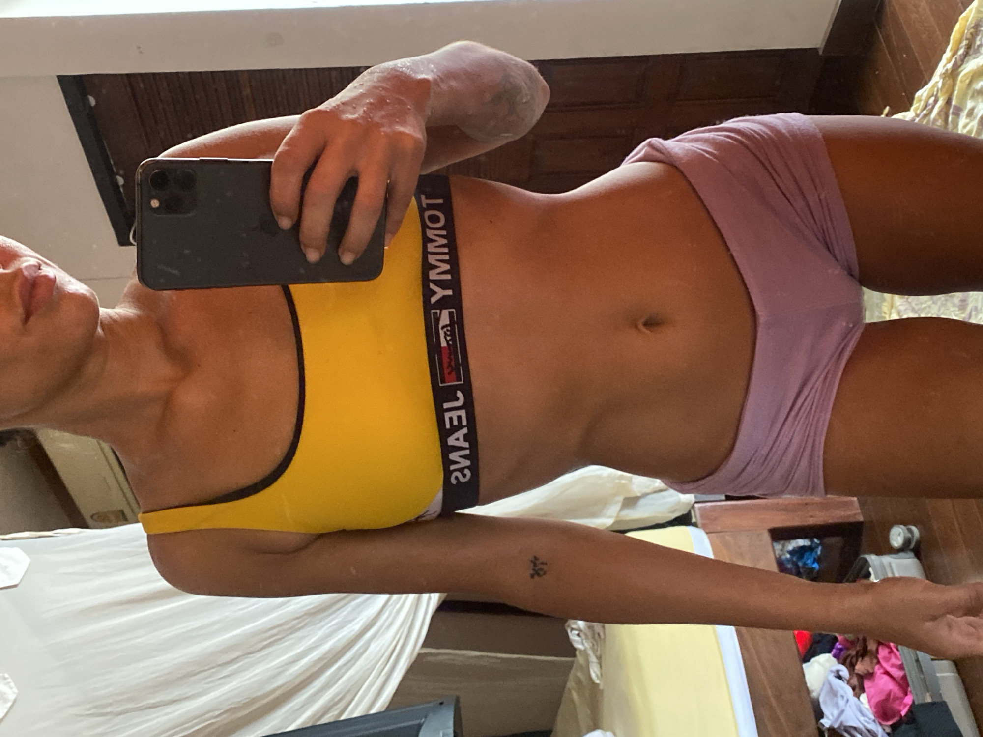 Mirror selfie session in a Ko Pha-ngan room, yellow sports bra.
