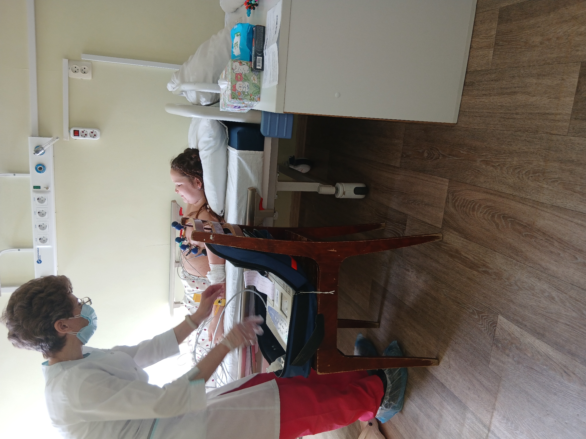 Medical staff attend young patient in hospital room