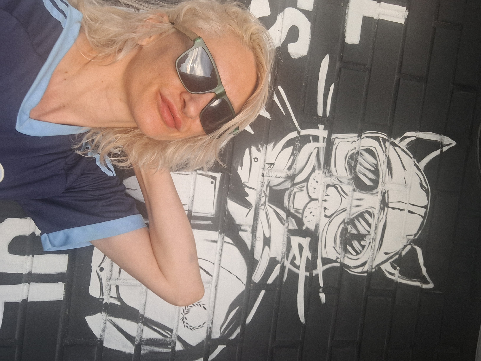 Selfies with a cat, in front of a cat mural