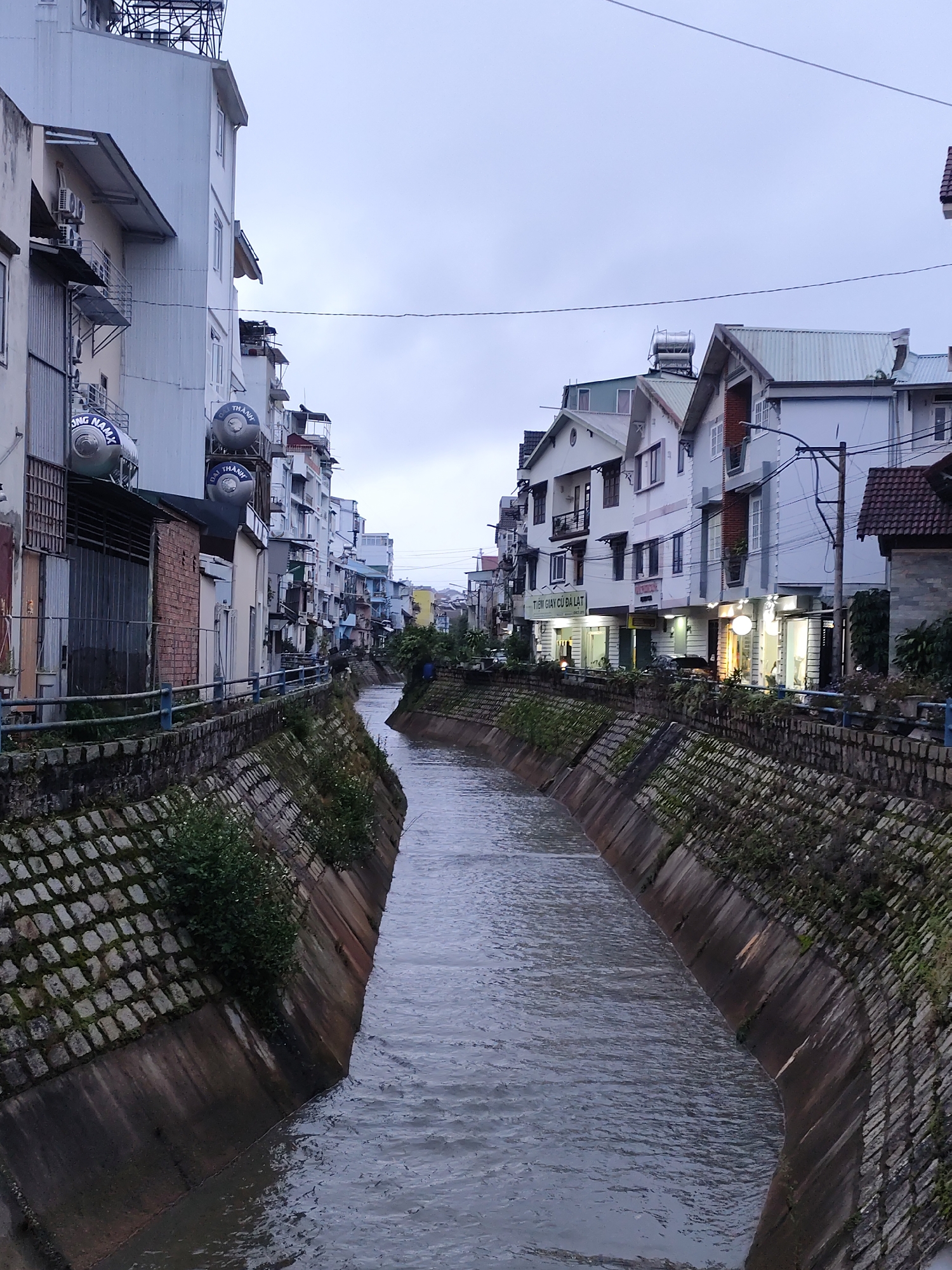 Canal-side streets and local shops in Da Lat at dusk
