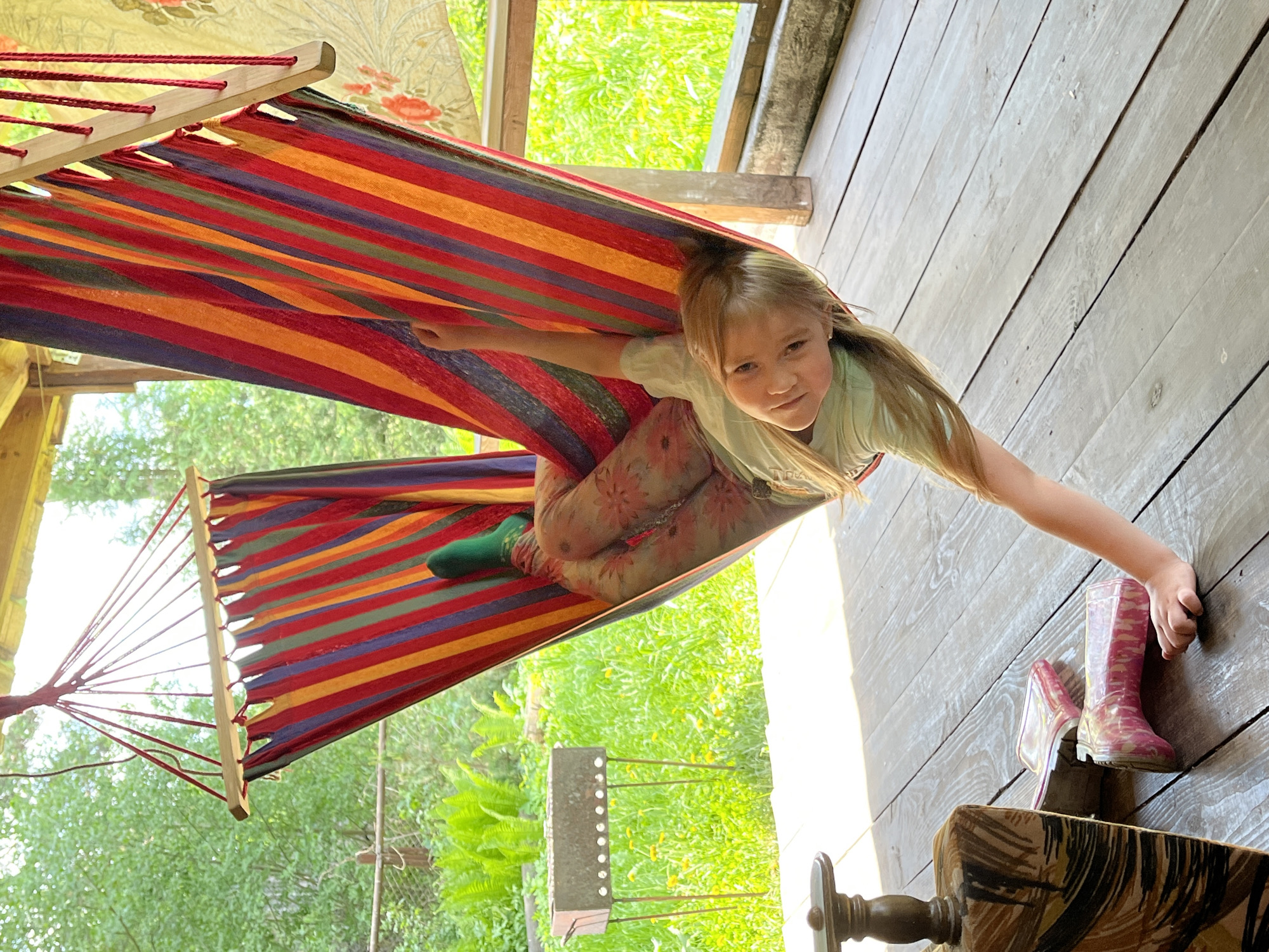 Child relaxes in striped hammock in Chaikovsky, Russia