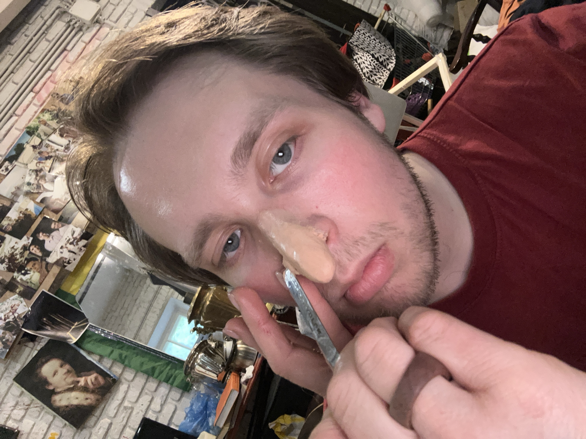 Person applies prosthetic nose makeup in multi-stage process