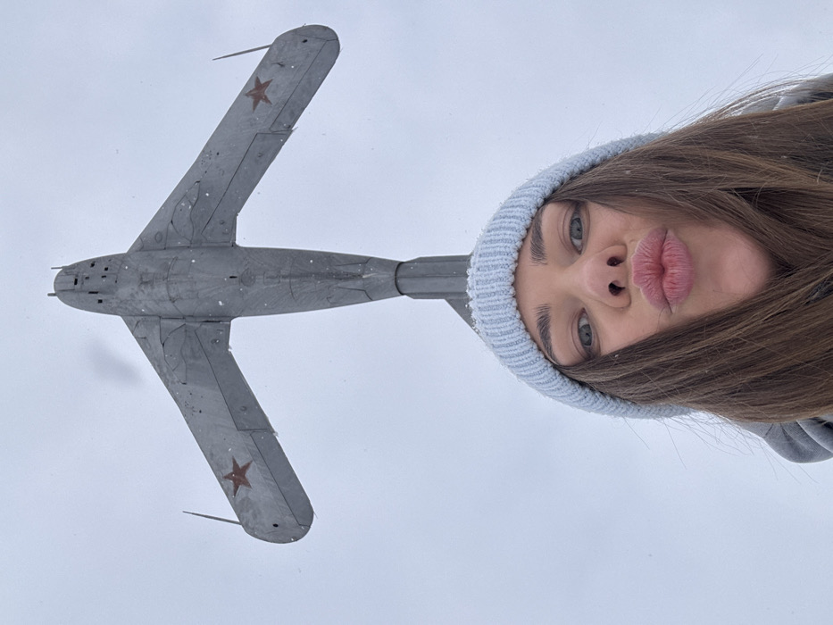 Woman photographs herself beneath MiG-15 monument in Chernushka