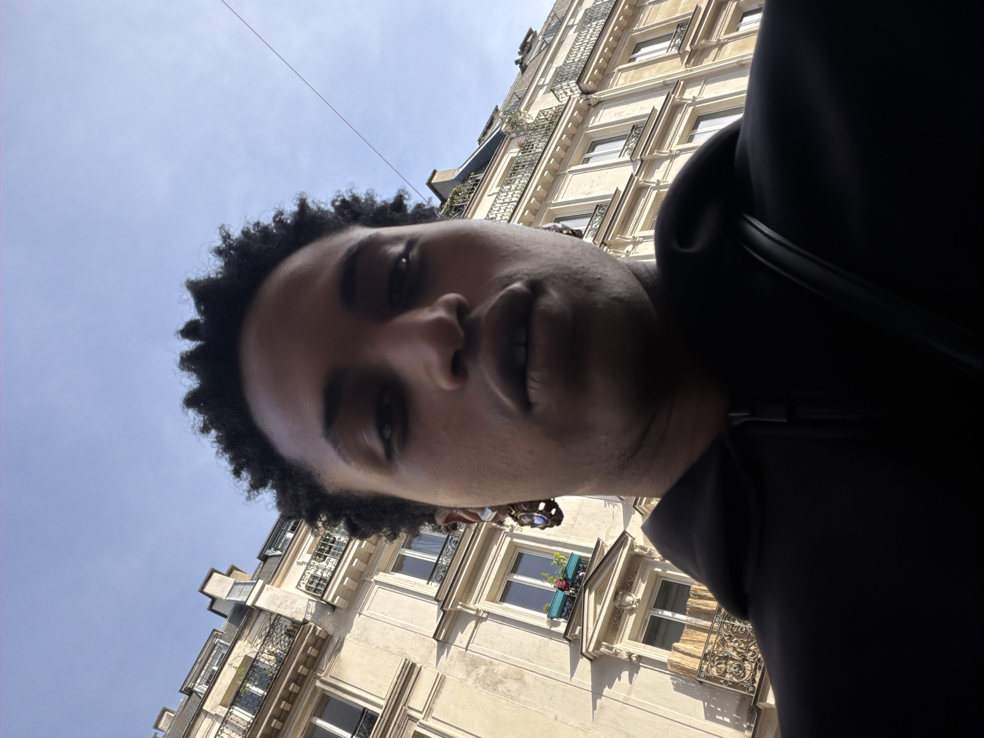 Person captures upward-gazing selfies on classic Paris street