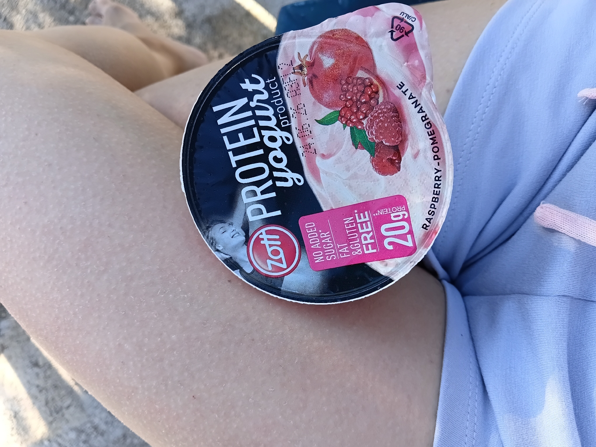 Woman rests with yogurt snack in Vlora bedroom