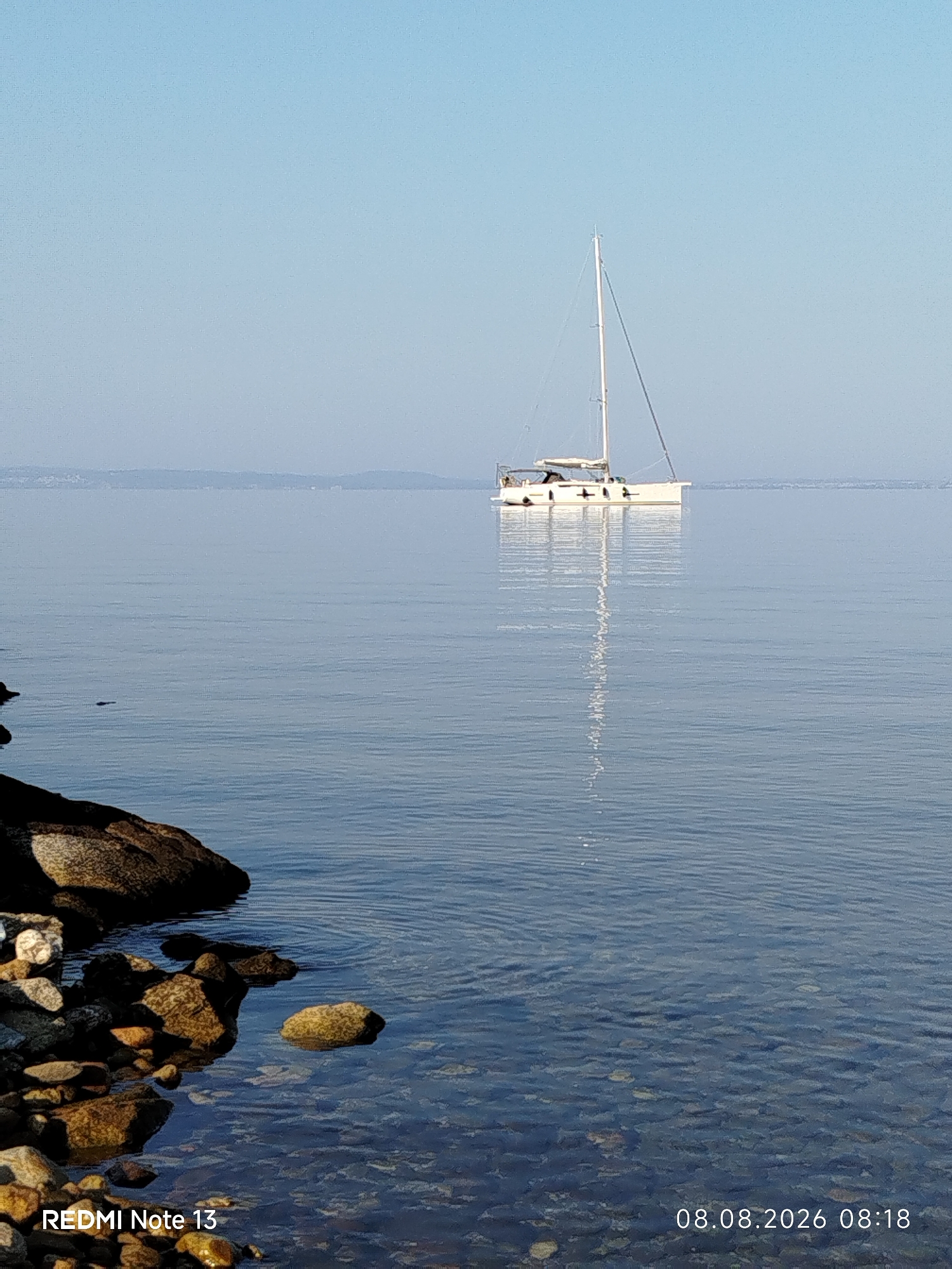 Calm morning on the Sithonian coast, sailboat anchored offshore