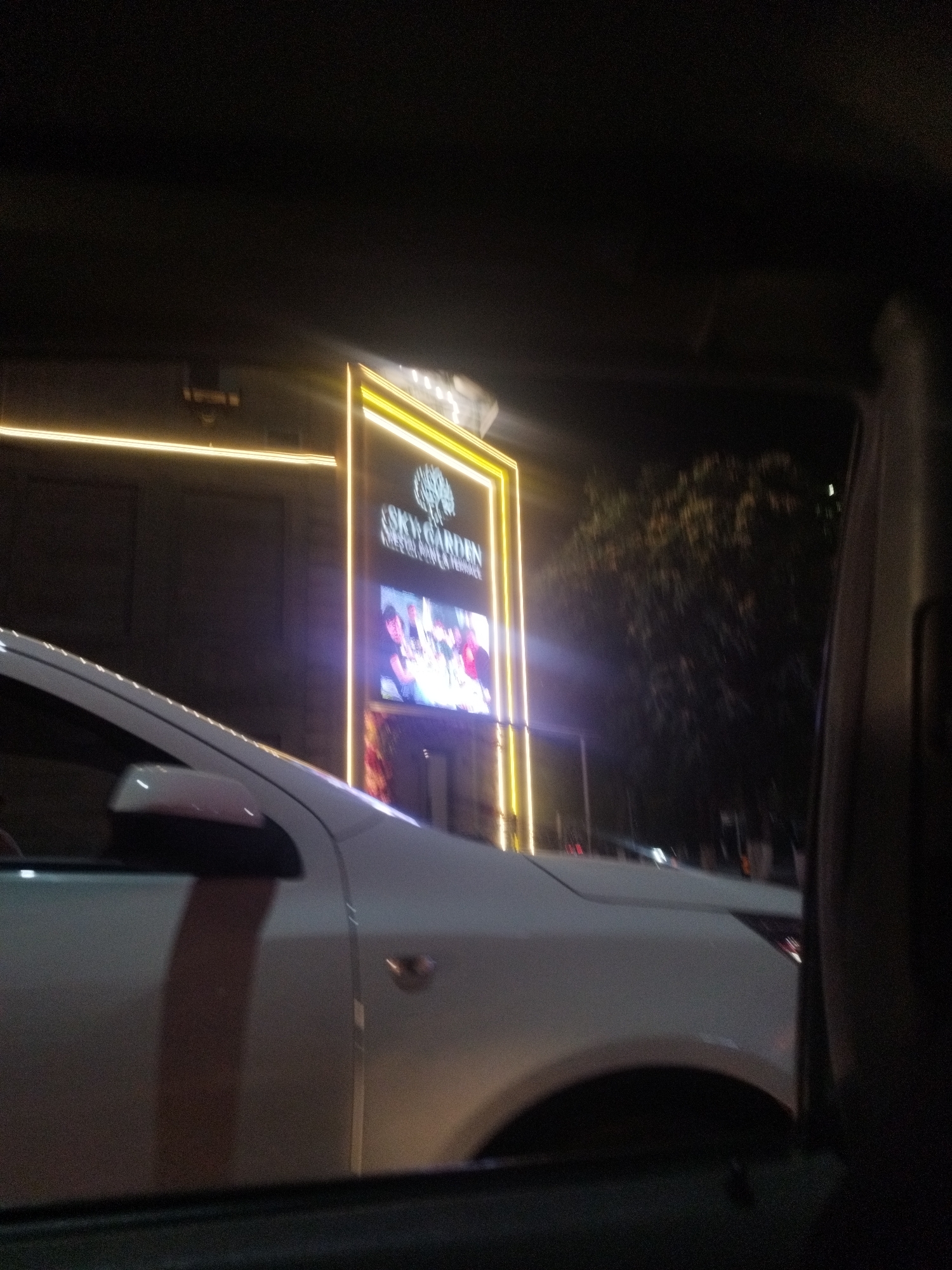 Neon-lit venues along a Shymkent street at night