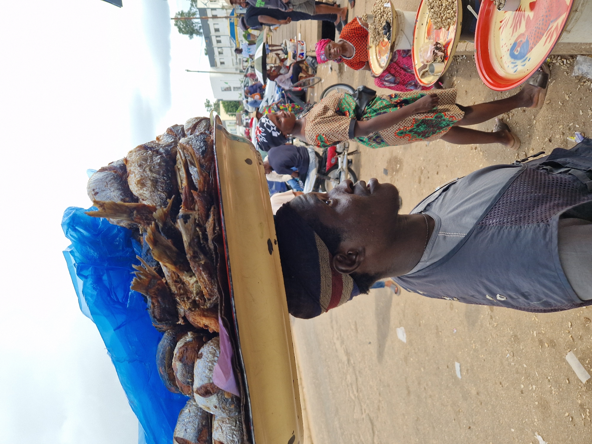 Street vendors and passersby in a lively outdoor market setting