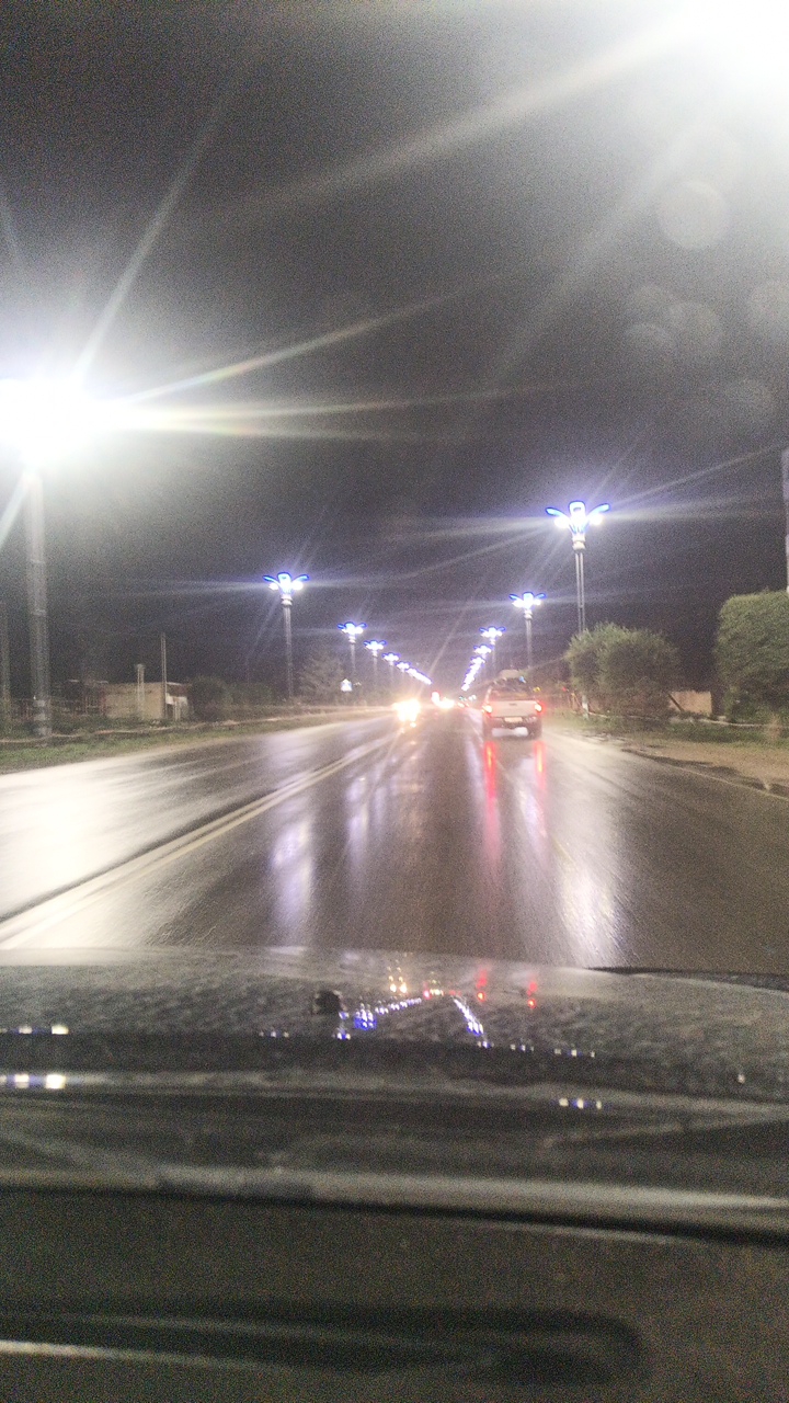 Wet streets and lit storefronts on a Balykchy night