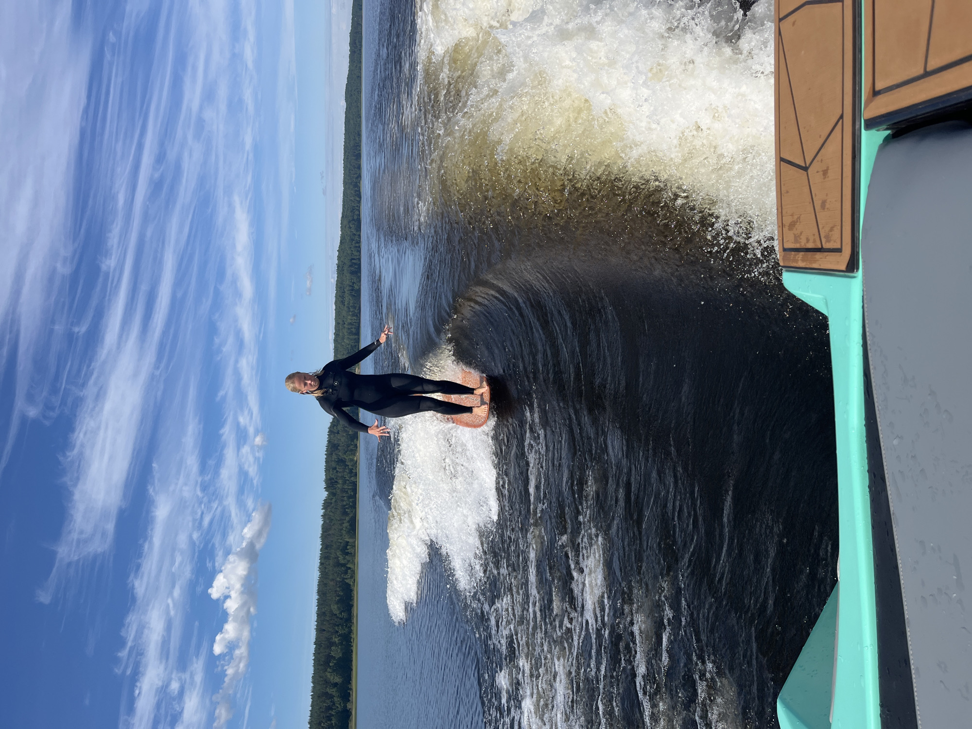 Wake surfing a calm Russian lake on a summer morning