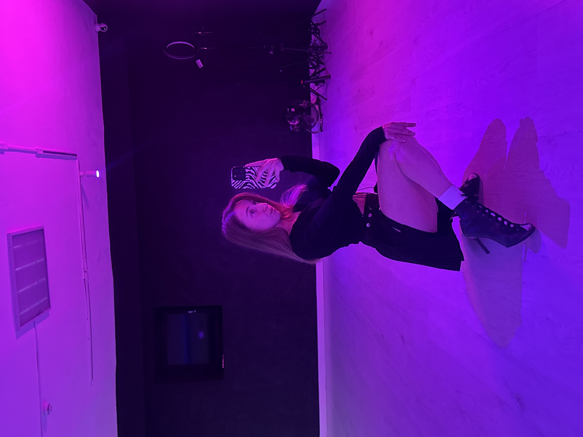 Woman poses for purple-lit selfie session in Chaikovsky