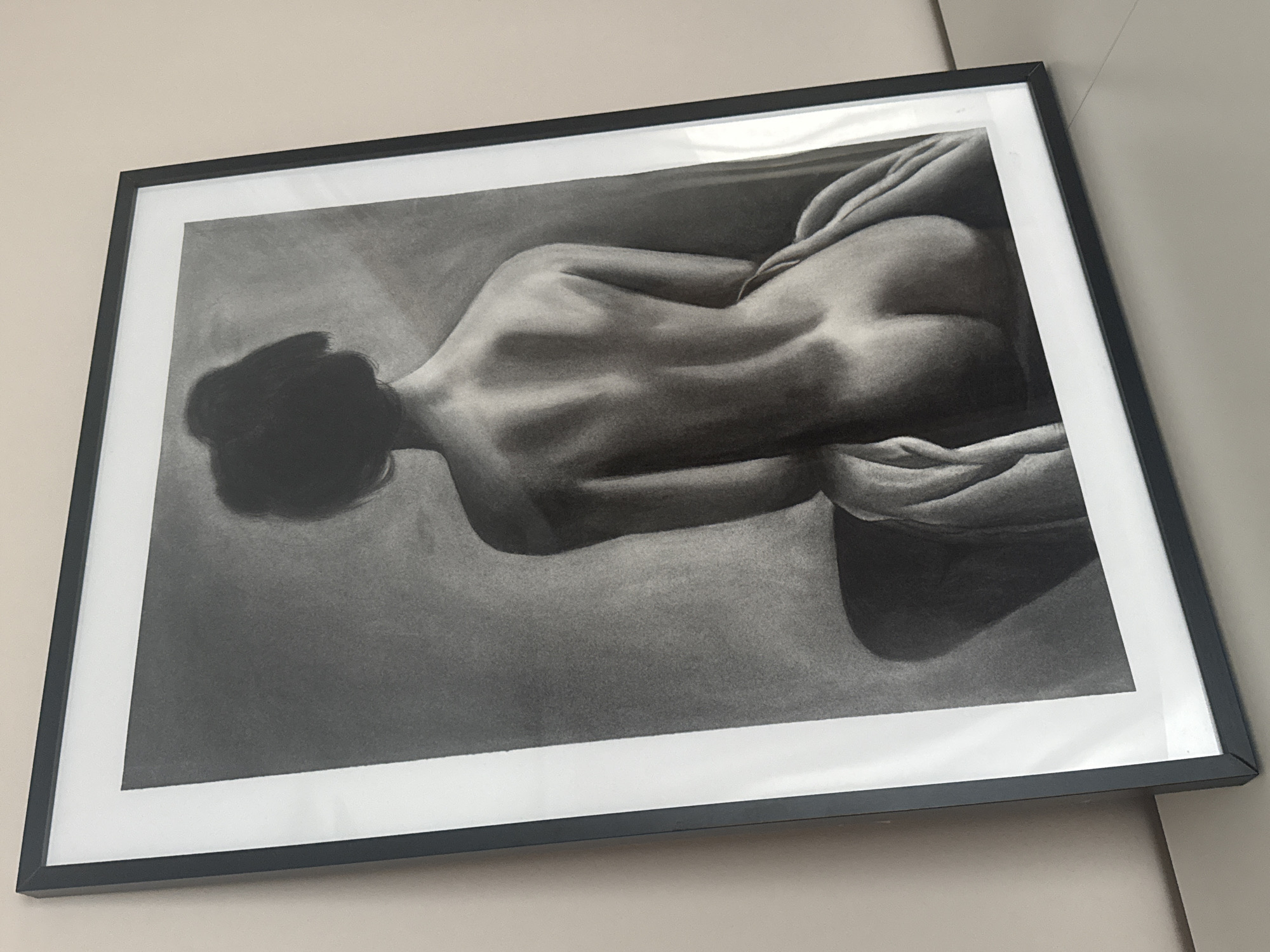 Charcoal nude drawing observed on wall display