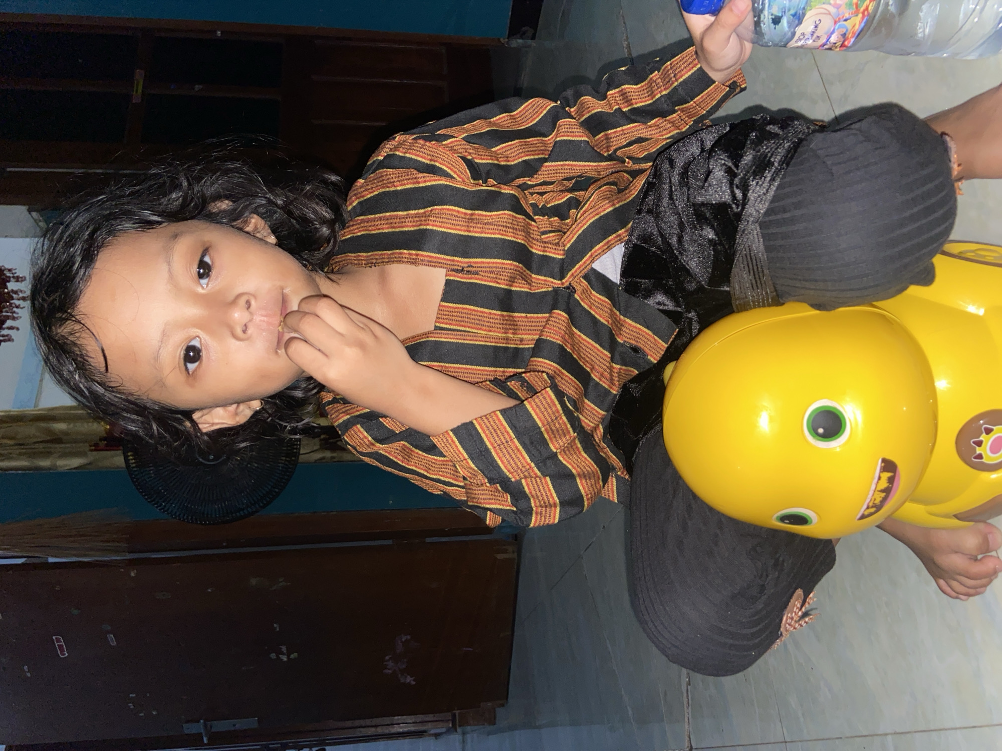 Child plays on yellow toy in Gelam, Indonesia