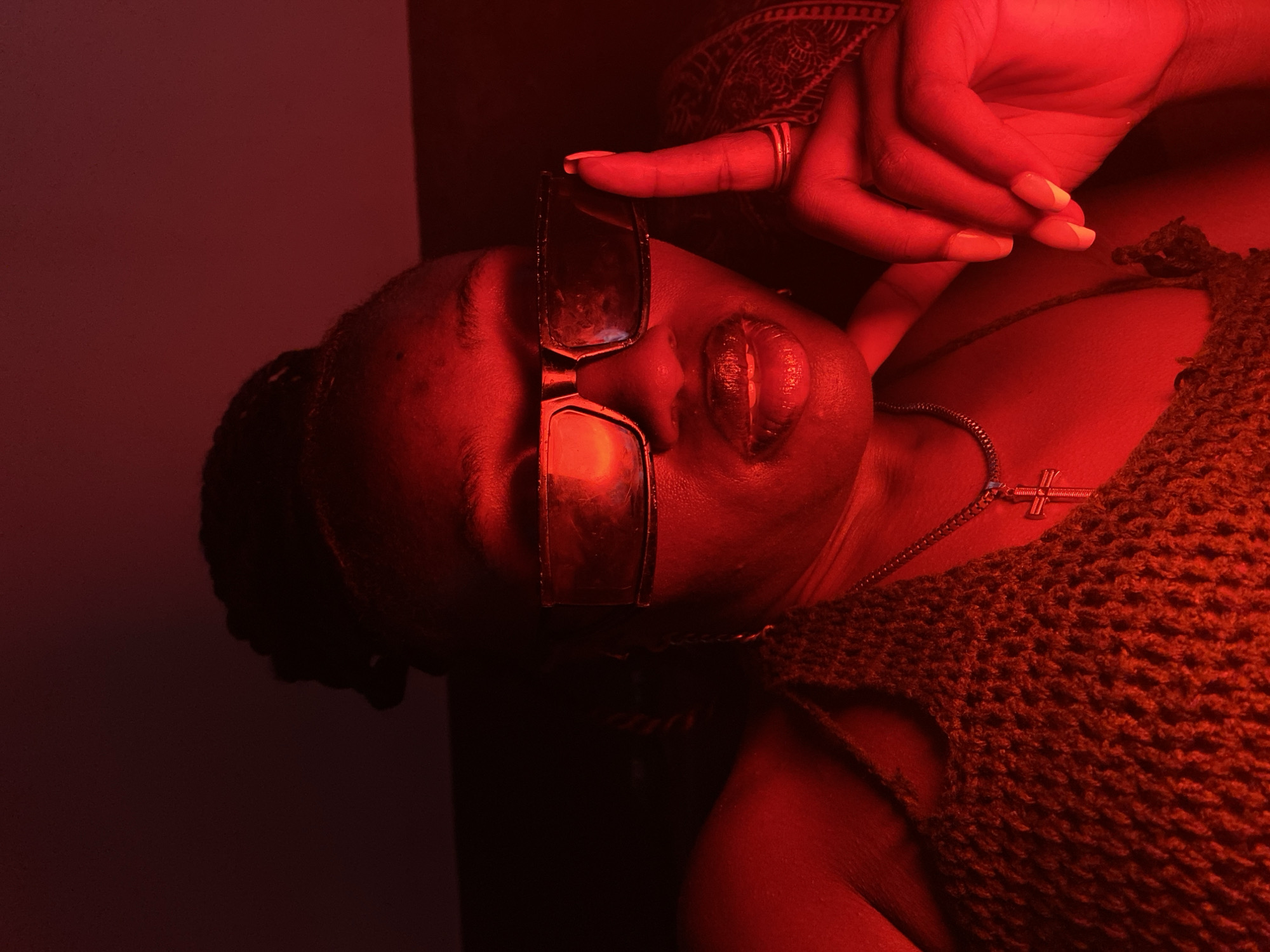 Woman relaxes on couch in colorfully lit Nigerian interior