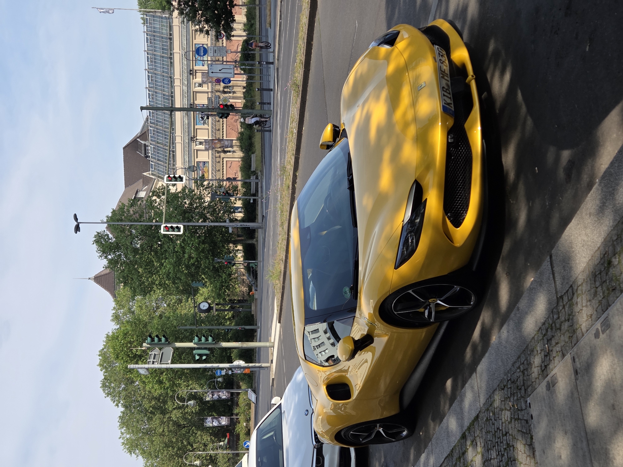 Yellow Ferrari and Aston Martin parked on a Berlin street