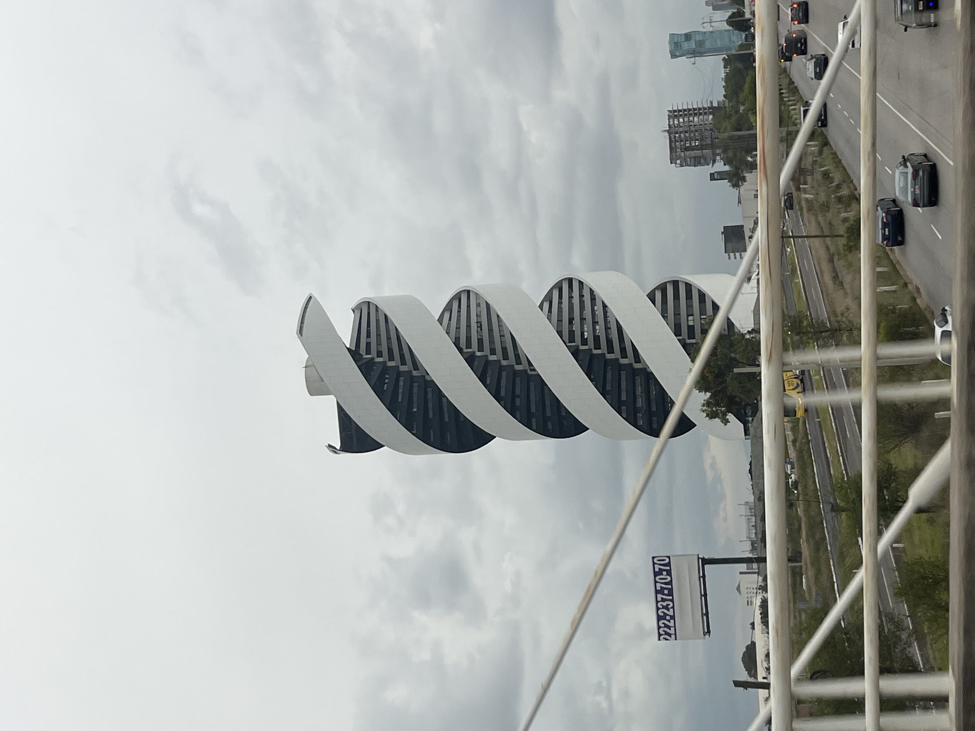 Torre Helix spiral skyscraper under cloudy skies, Puebla