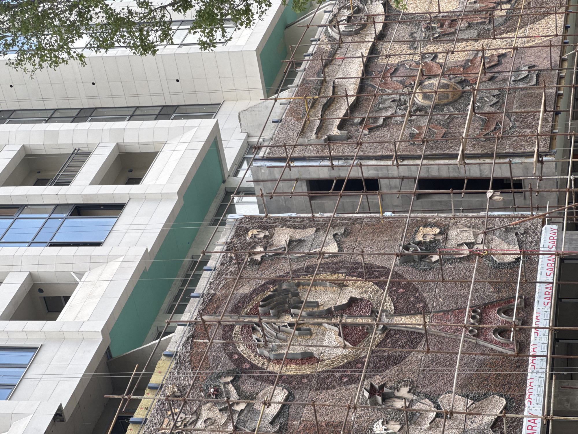 Building renovation features mosaic artwork on facade