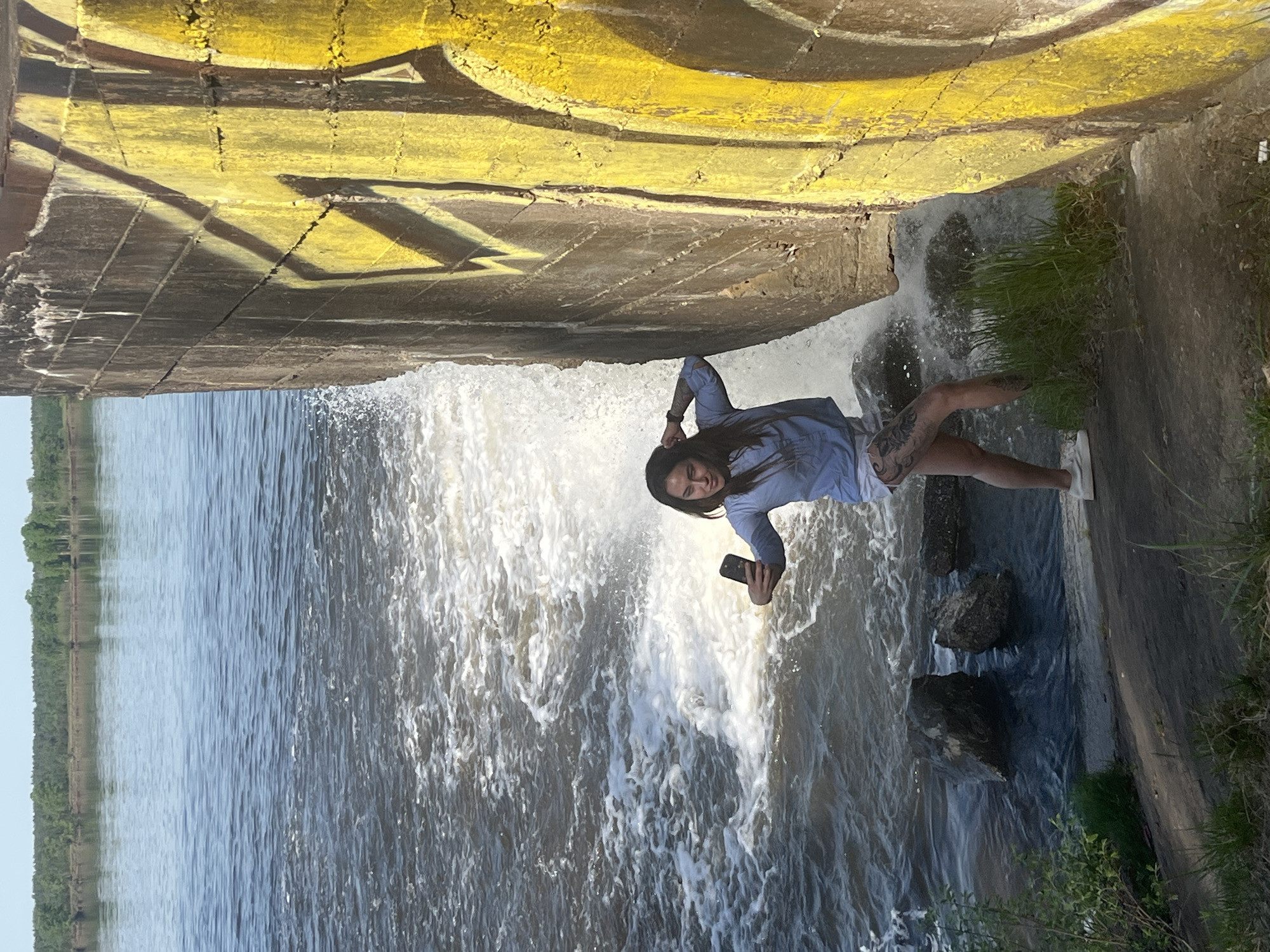Woman takes selfies at active waterfall in Chernushka, Russia