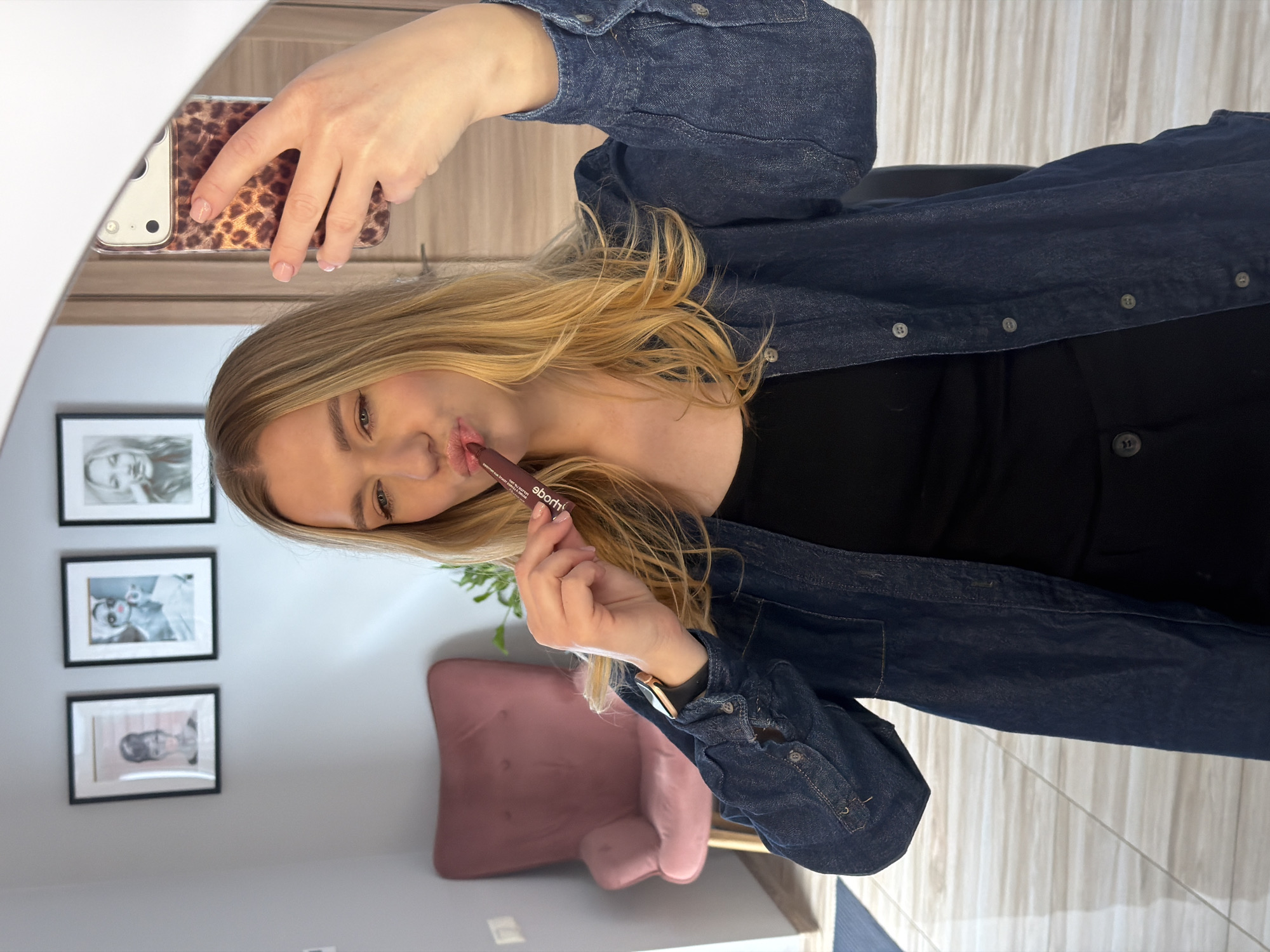 Woman applies makeup during morning routine in Riga