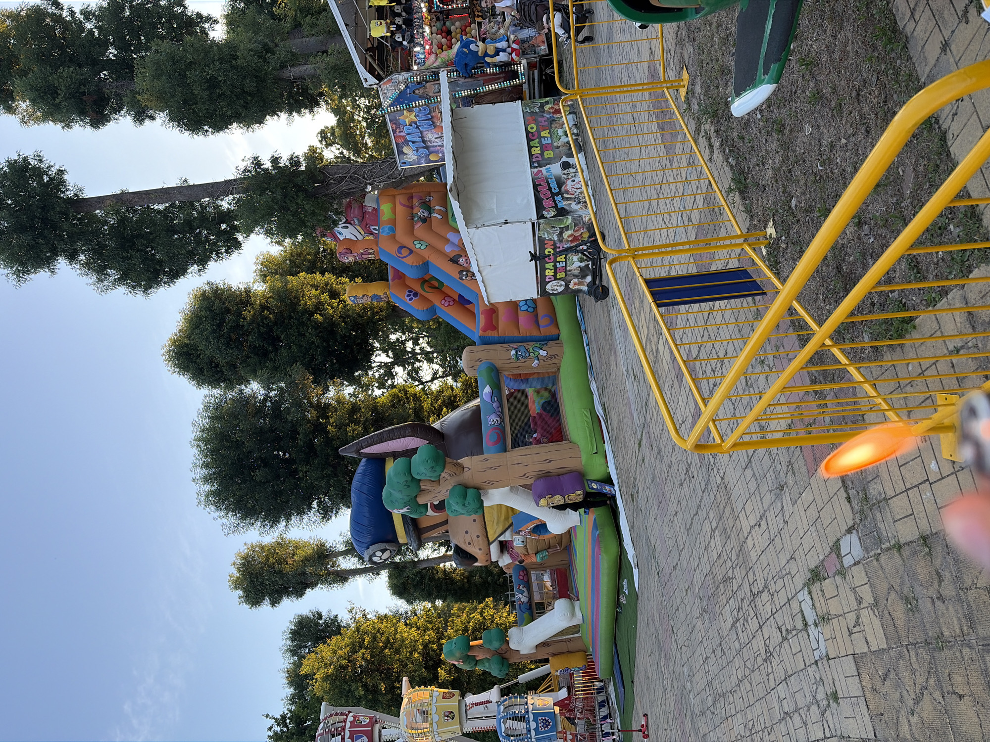 Afternoon at an outdoor carnival with rides and prize stalls