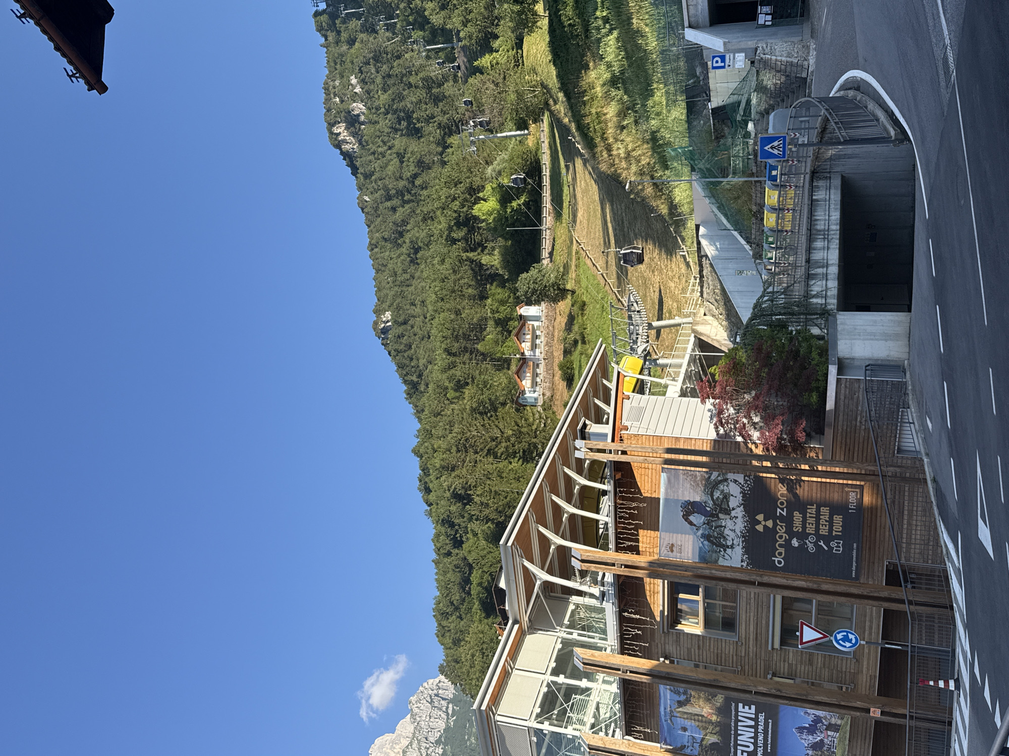 Molveno's lake, cable car, and Dolomite backdrop on a clear morning