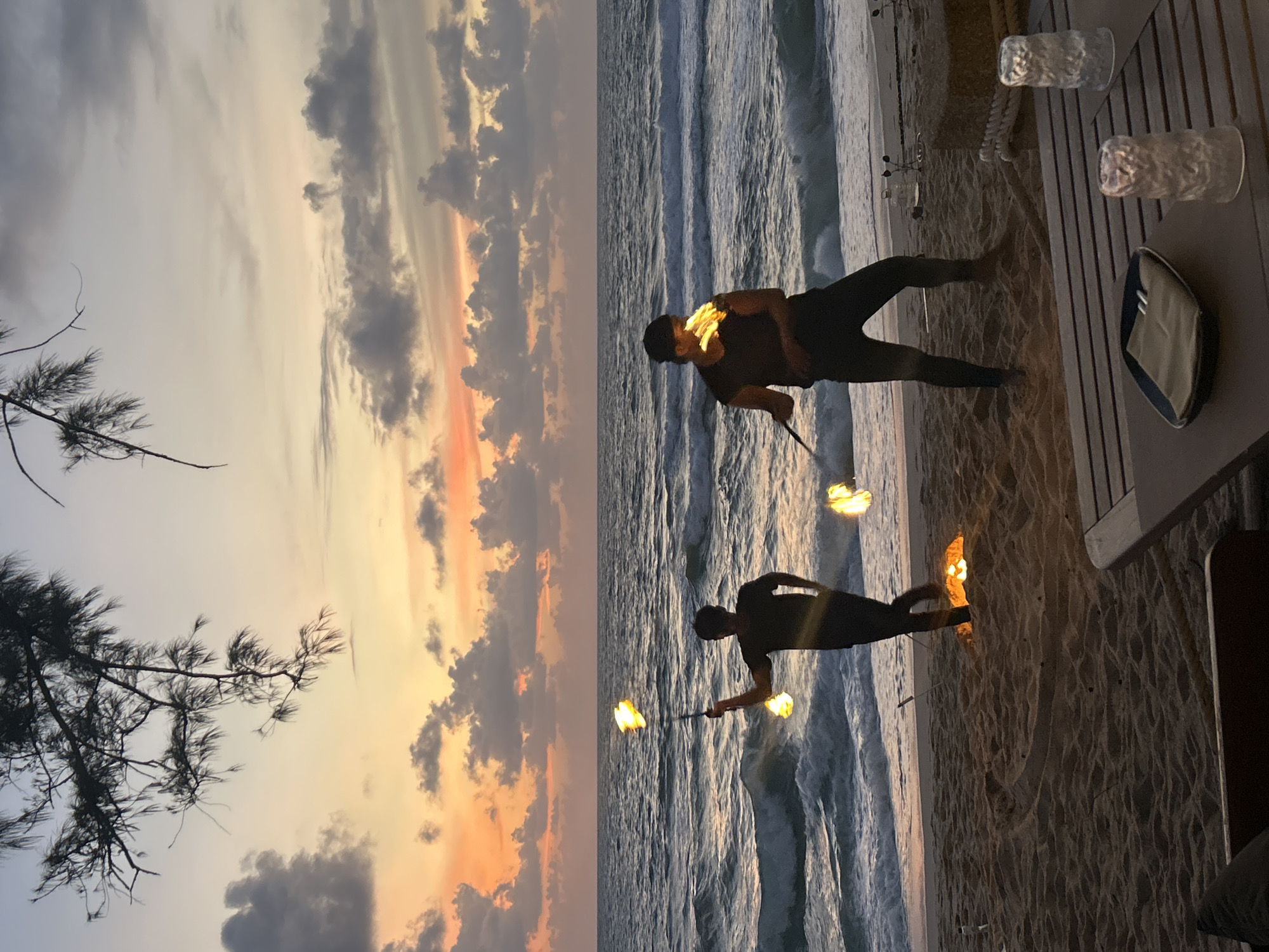 Fire spinning performance on a Choeng Thale beach at dusk