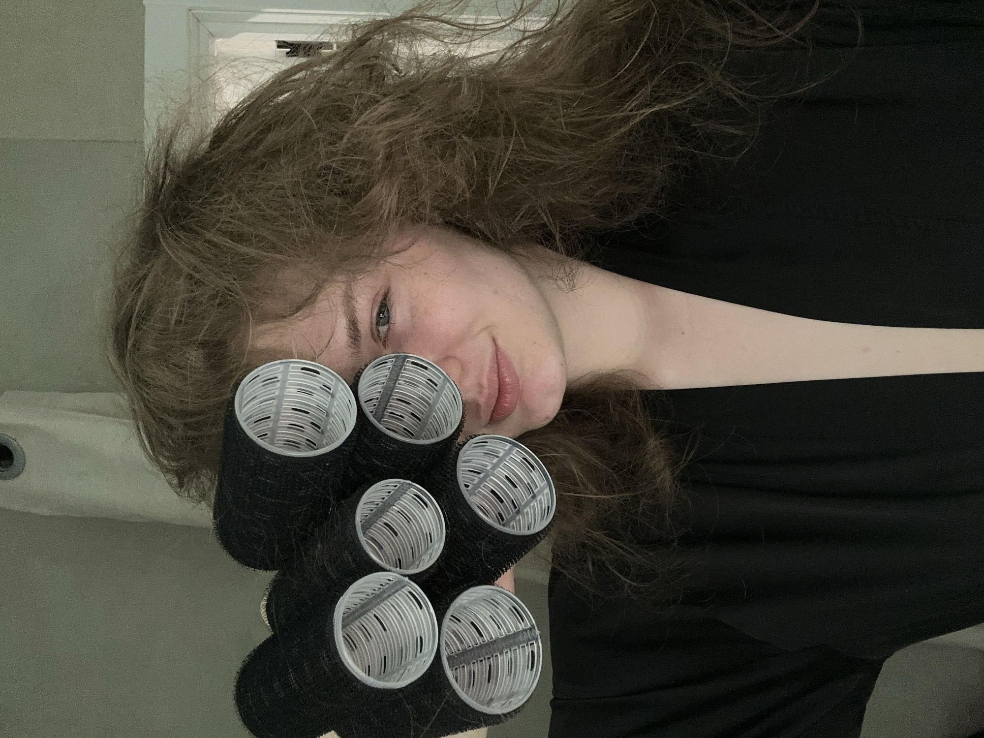 Woman uses hair rollers during beauty routine in Kazan