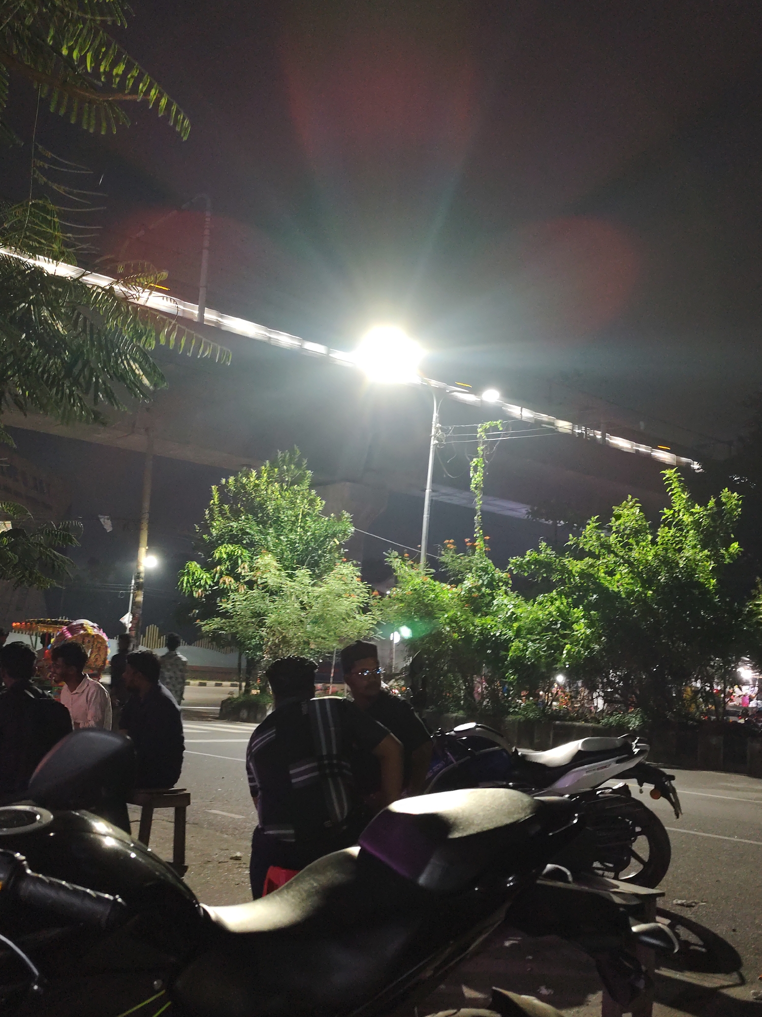 Evening street vendors serve customers in bustling Dhaka commercial district