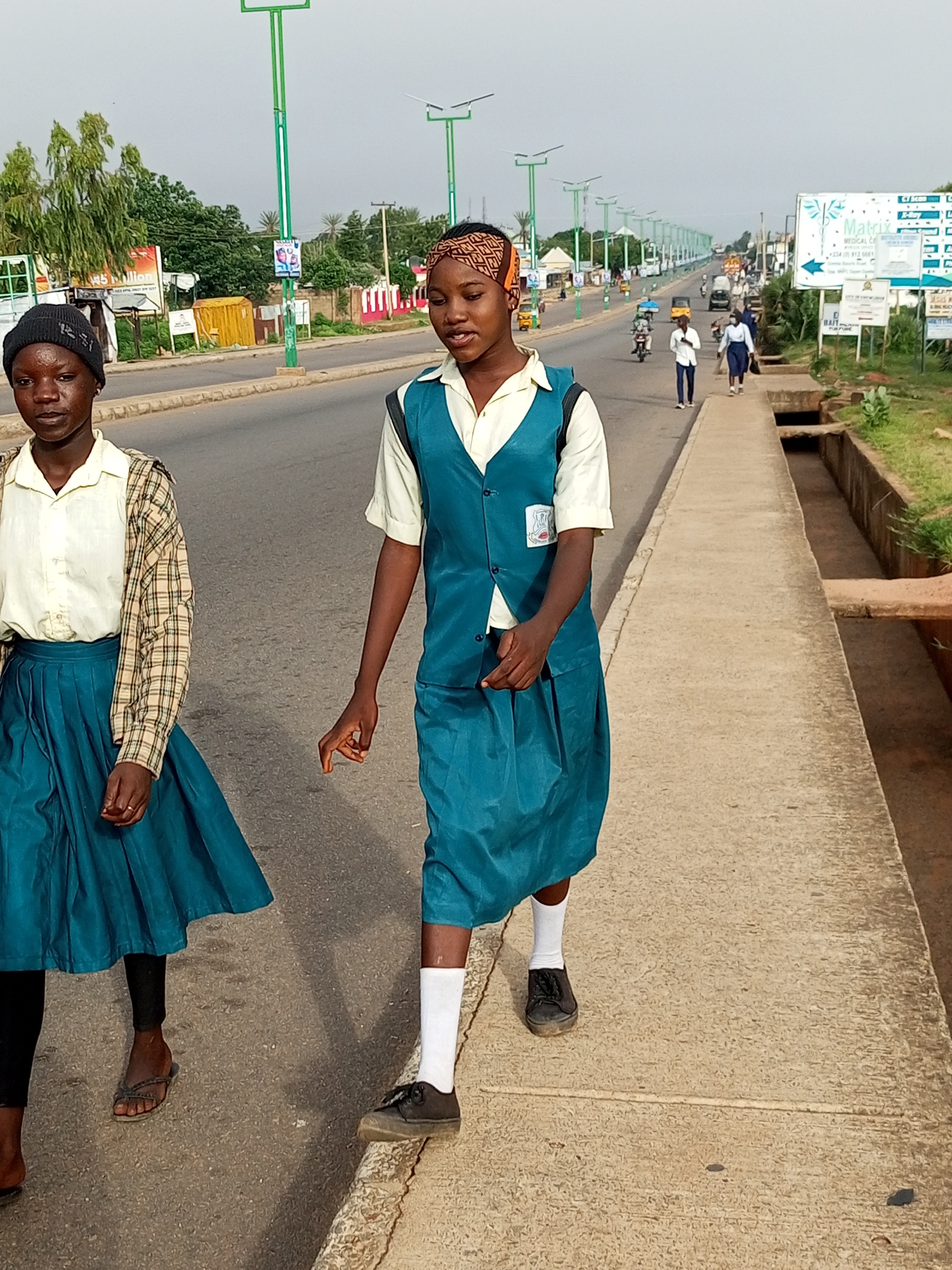 Morning street activity across three Nigerian towns, mostly school commuters