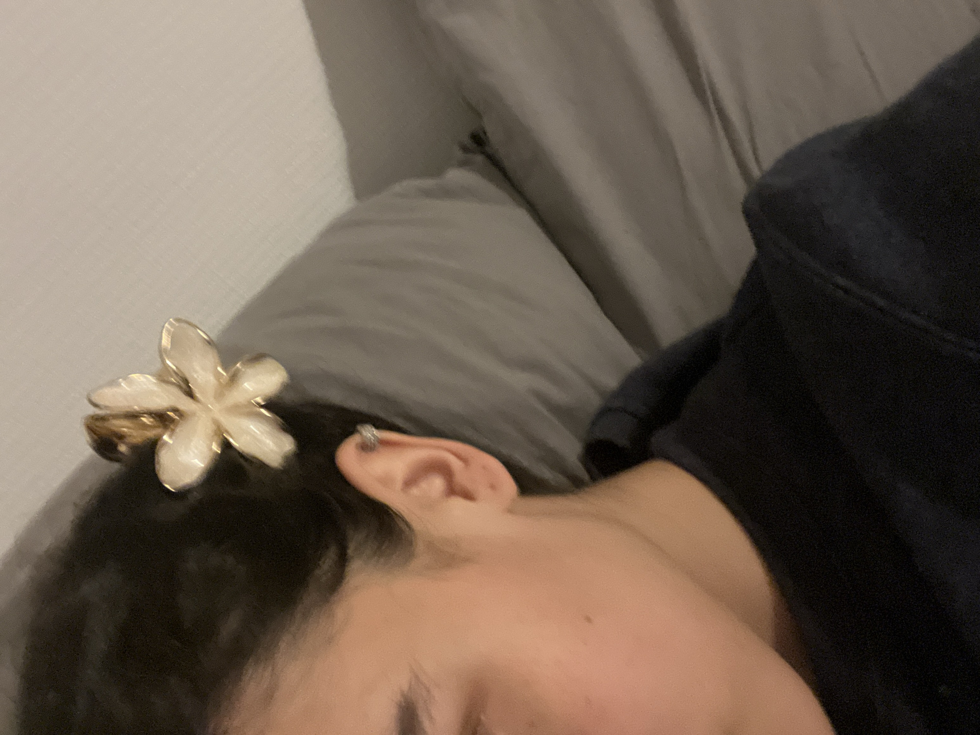 Person rests in bed with iPad, flower hair clip in Lyon