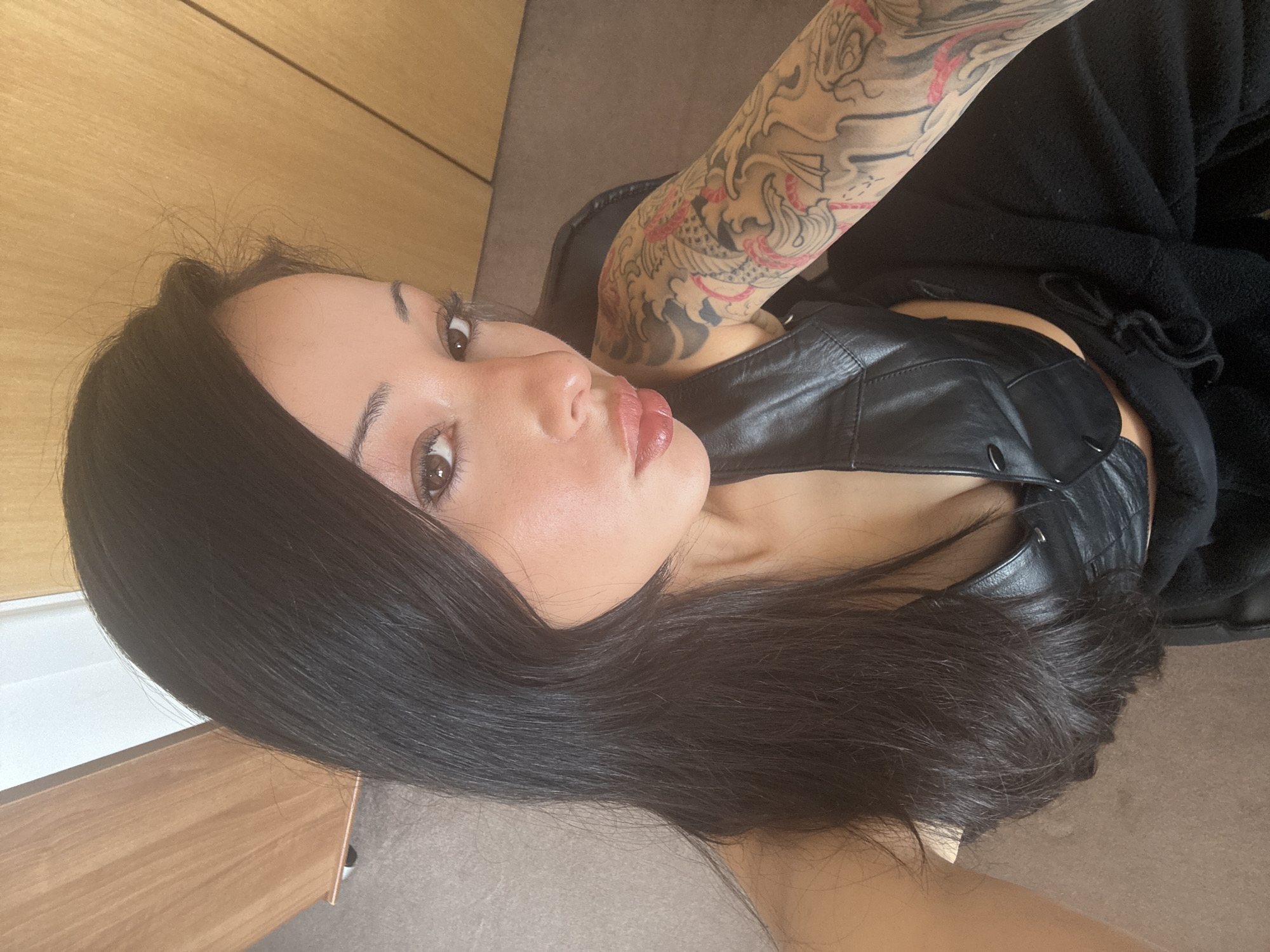 Woman takes selfies in black leather top in London
