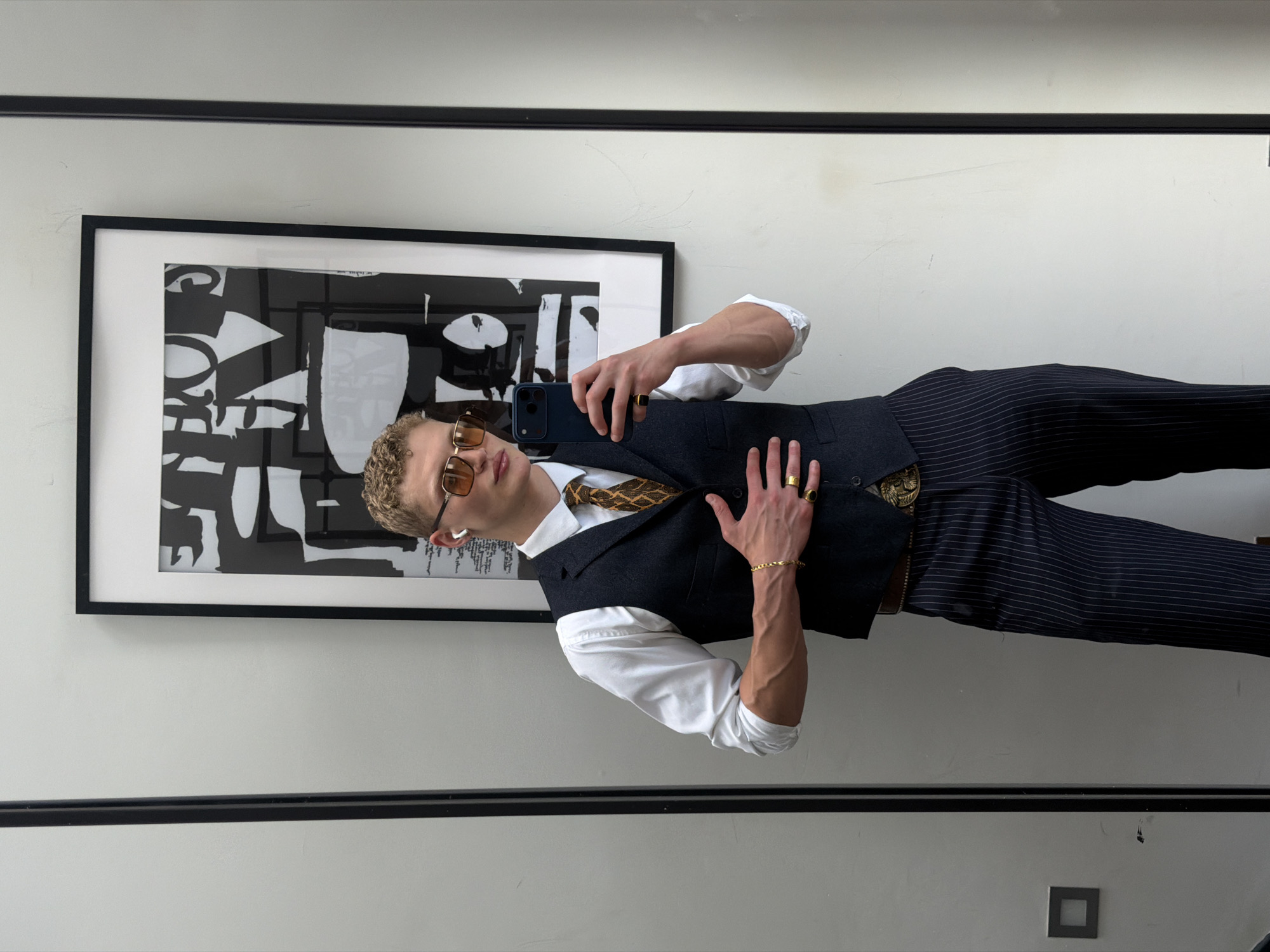 Mirror selfie in a London room with abstract art backdrop