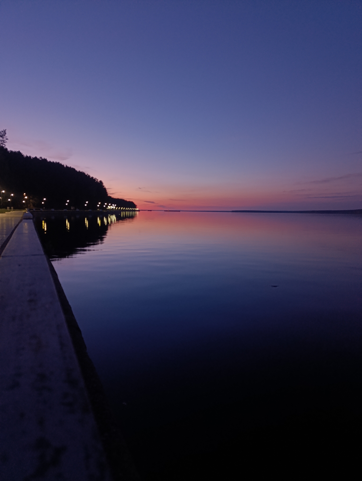 Evening skateboarding session documented along waterfront during twilight hours