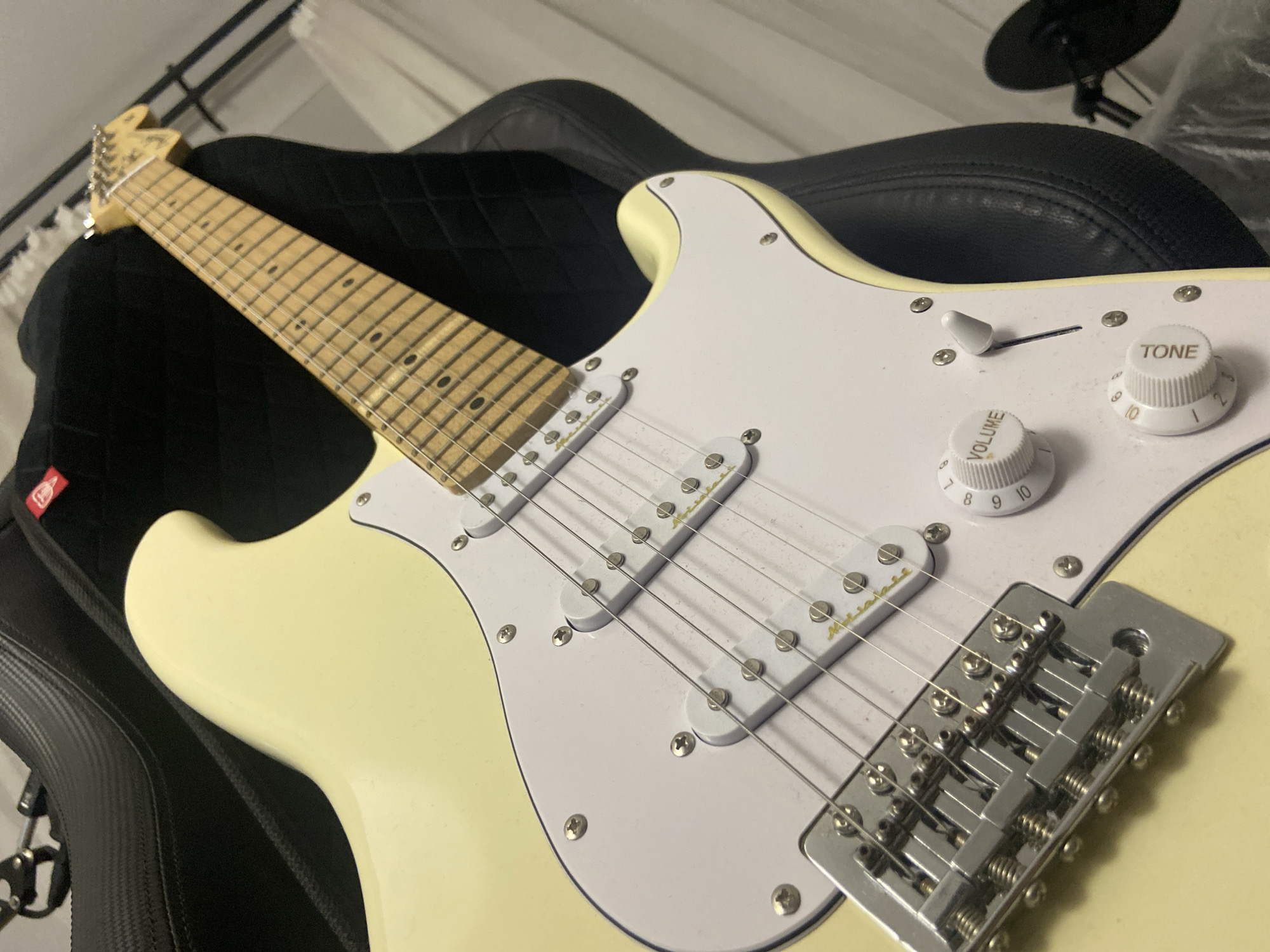 Two electric guitars, cream and black, laid out on padded surfaces