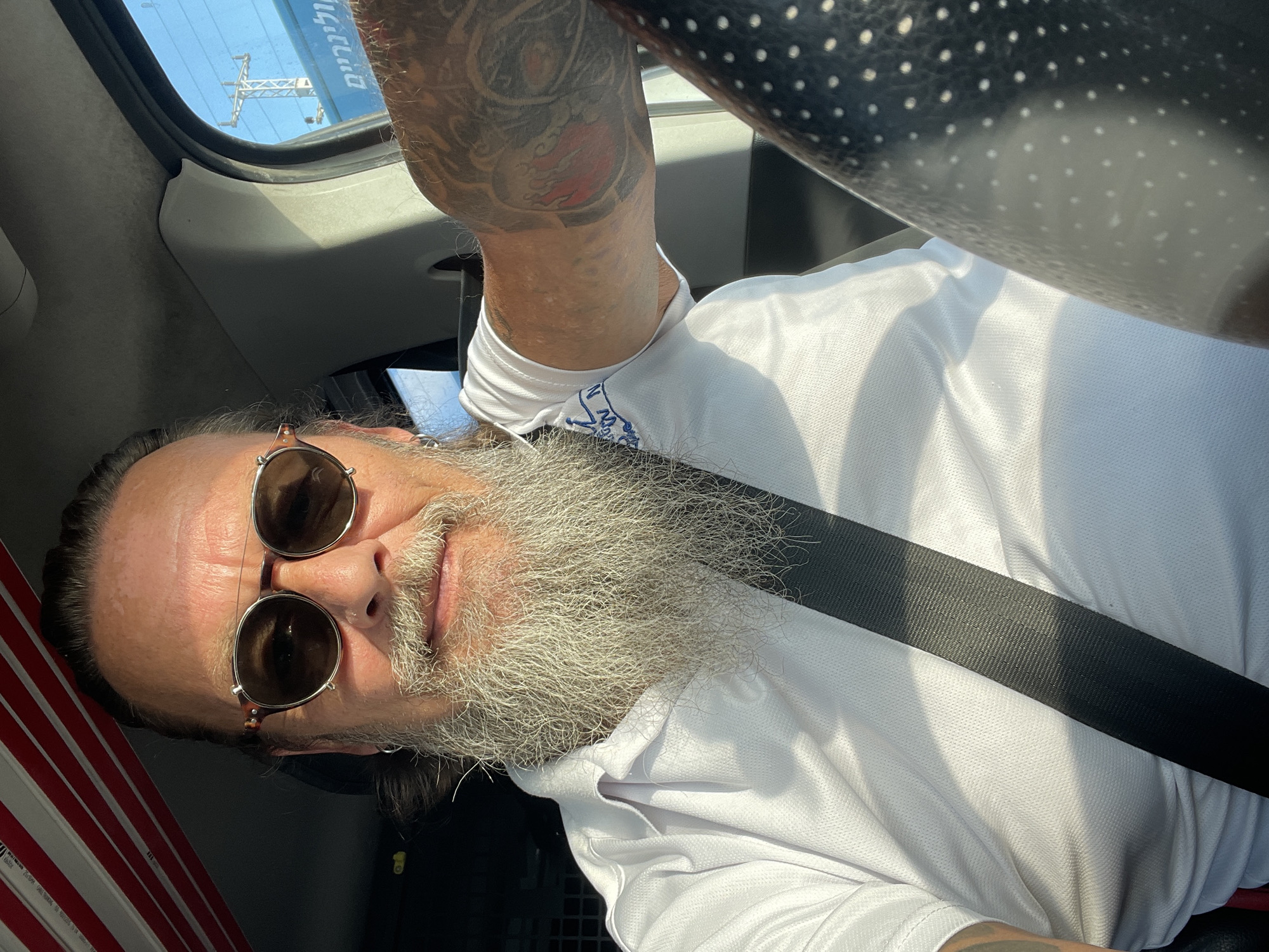 Driver's seat selfie in Beit Yehoshua, gray beard and shades.